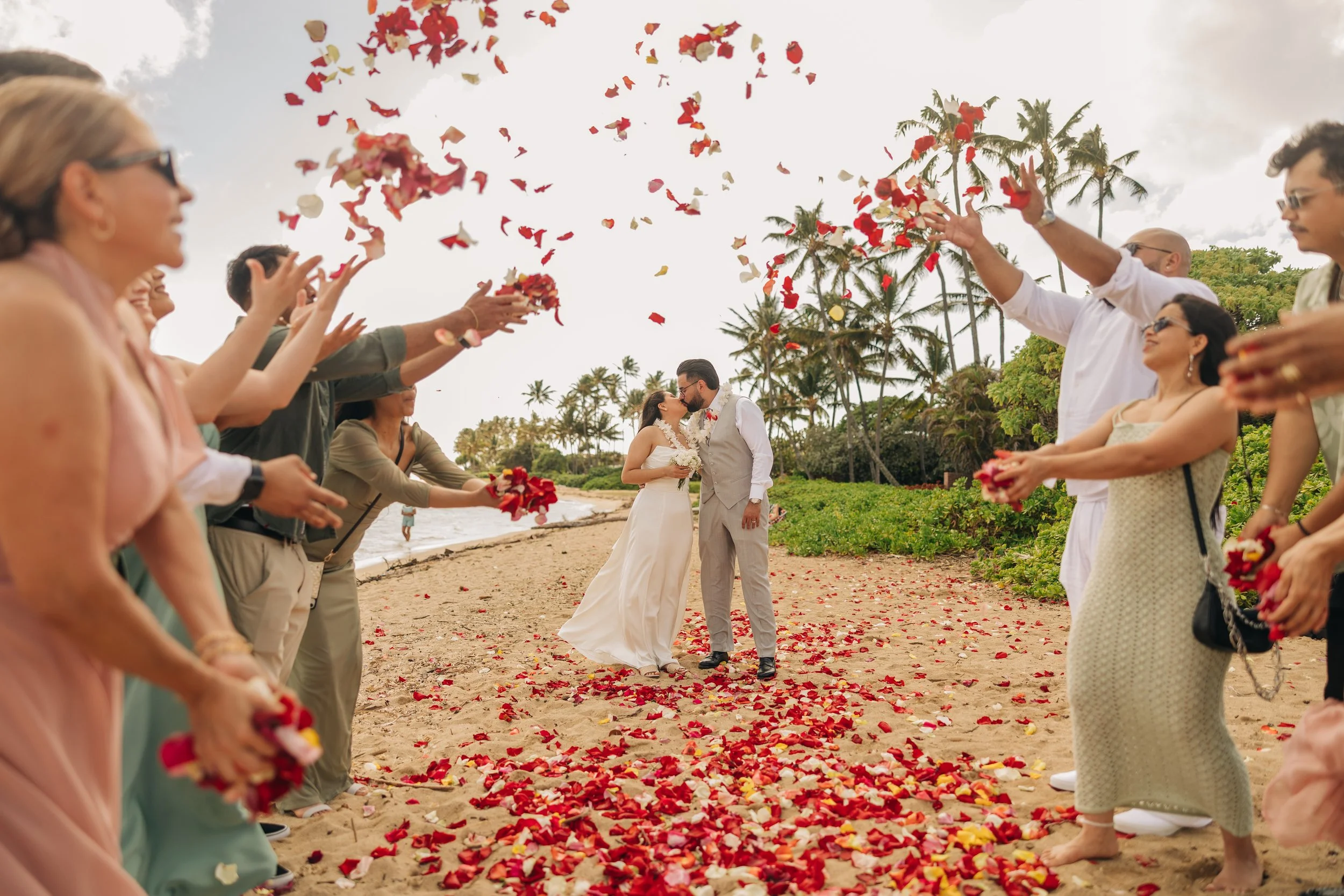 Couple Celebrate With family and friends and seal their vows with a kiss on Waialae Beach.