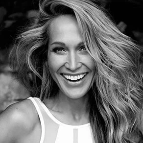 Black and white photo of a woman with wavy hair smiling