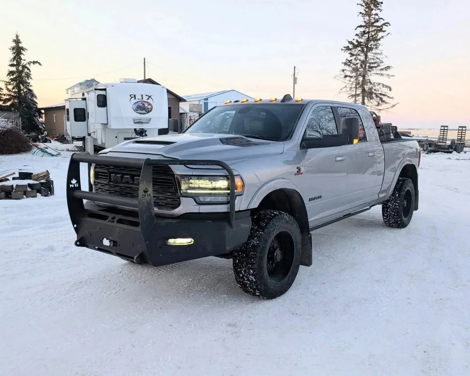 White RAM truck with heavy-duty steel front bumper parked on snowy driveway