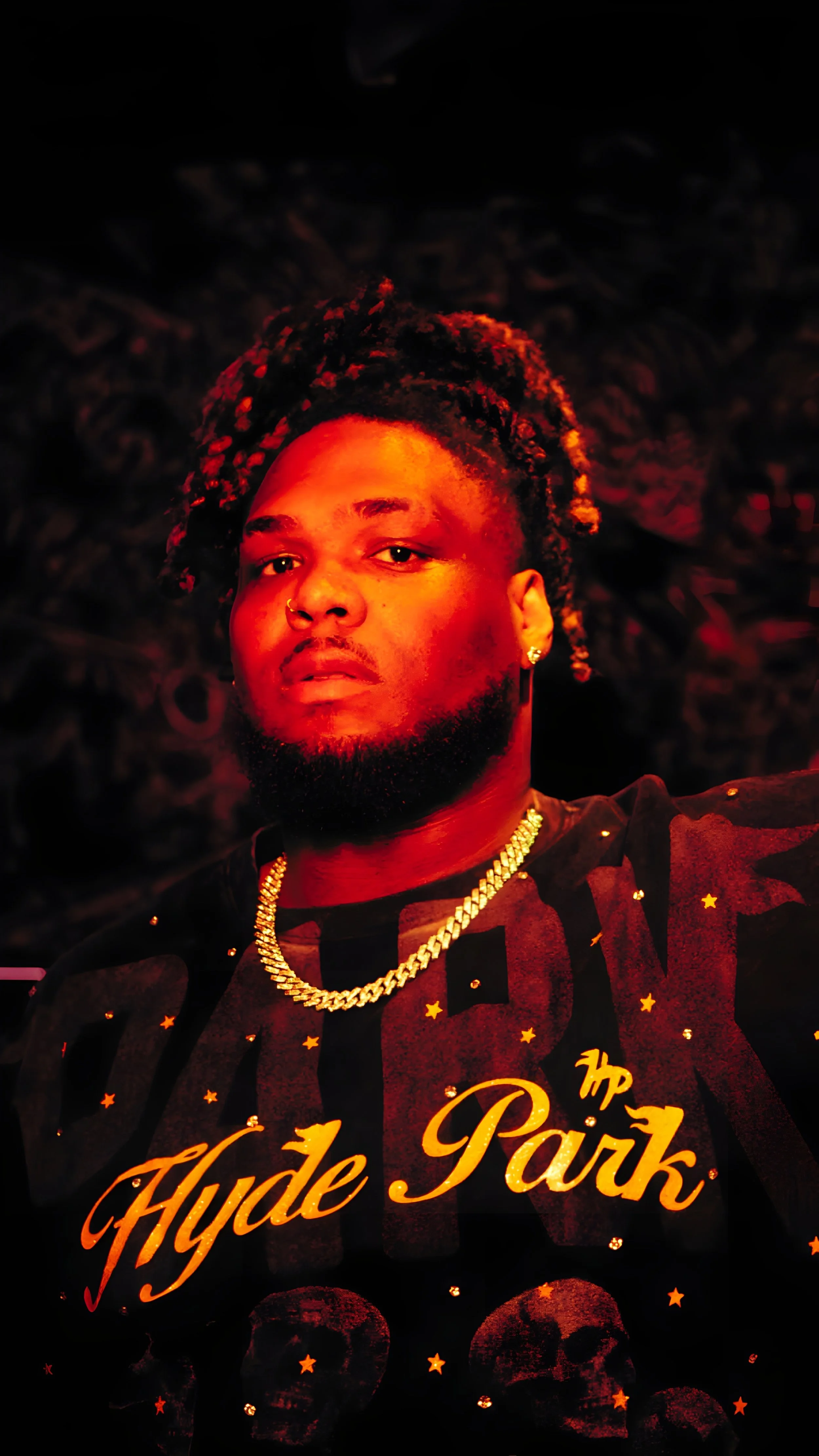 A young man with dreadlocks, wearing gold jewelry and a black T-shirt with 'Hype Park' printed on it, posing against a dark background.