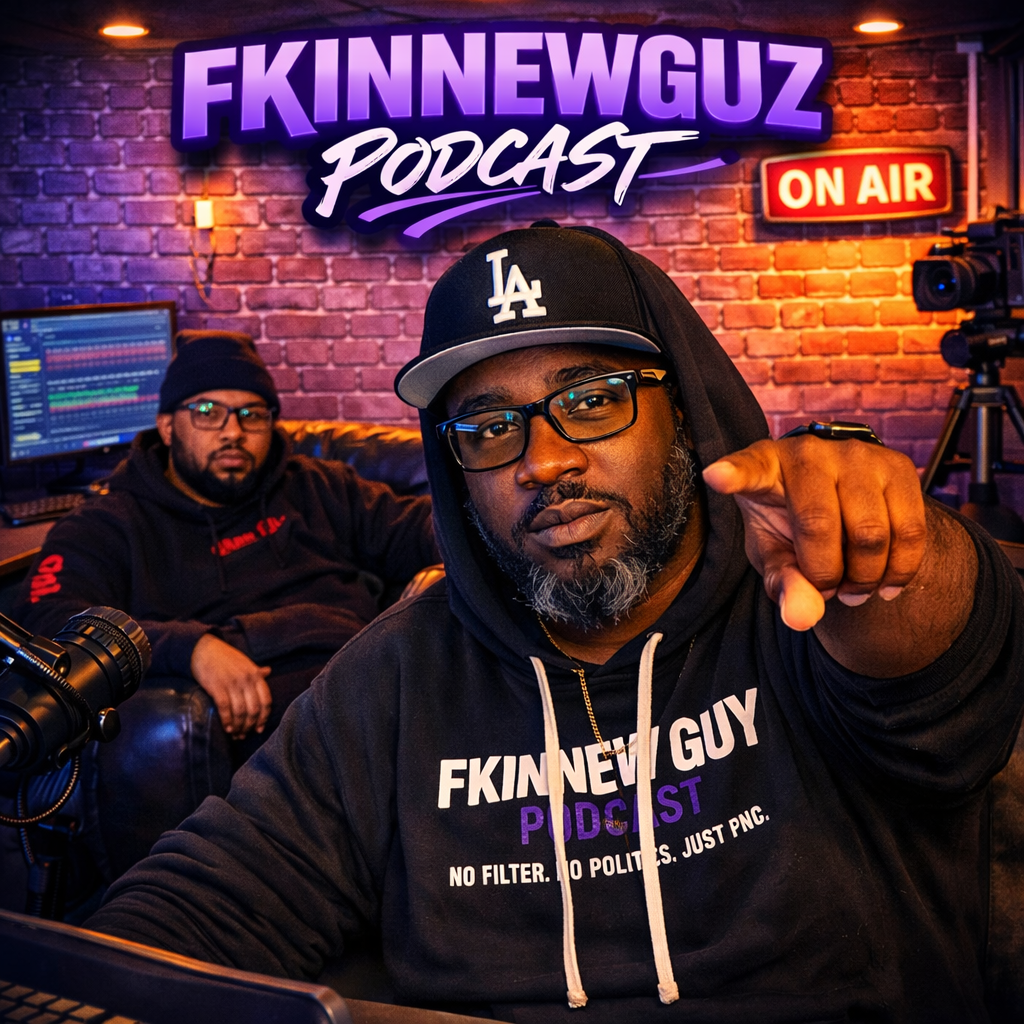 Two men in a radio studio with a sign reading 'FKINNEWGUZ PODCAST' and 'ON AIR' sign in the background. The man in the foreground is wearing glasses, a black hoodie, and a black 'LA' cap, and is pointing towards the camera. The man in the background is sitting on a couch, wearing glasses, a beanie, and a black hoodie, with a computer monitor showing audio waveforms behind him.