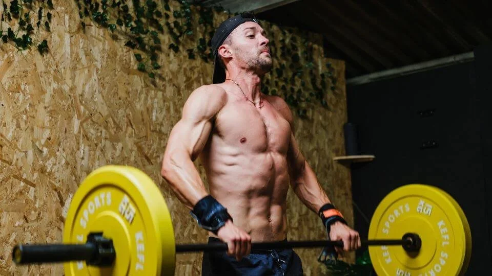 Personal Trainer lifting barbell in a gym.