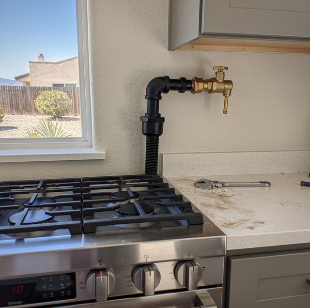 Copper gas pipe with yellow shutoff valve extending toward wall