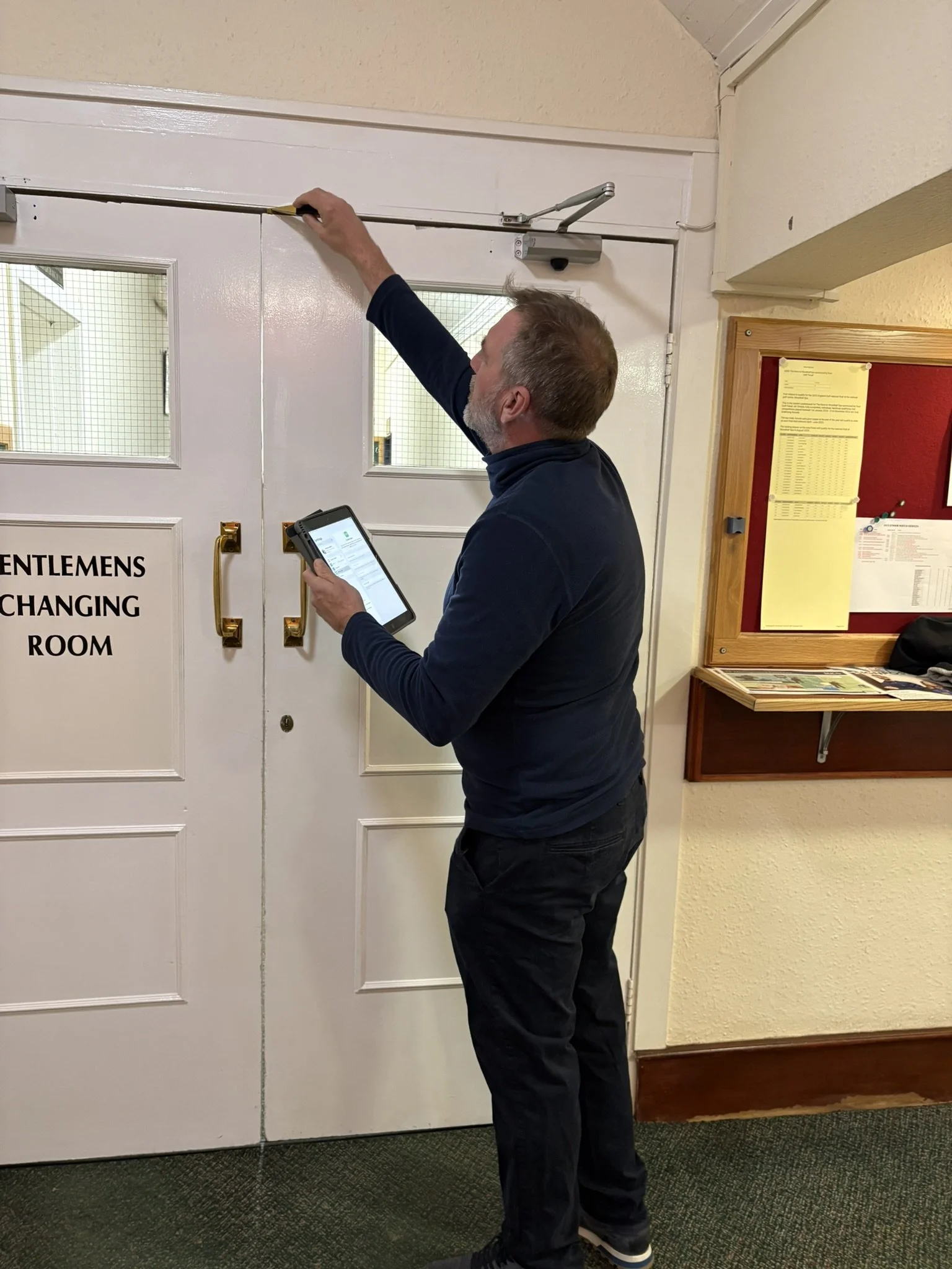 A man completing a fire door survey.