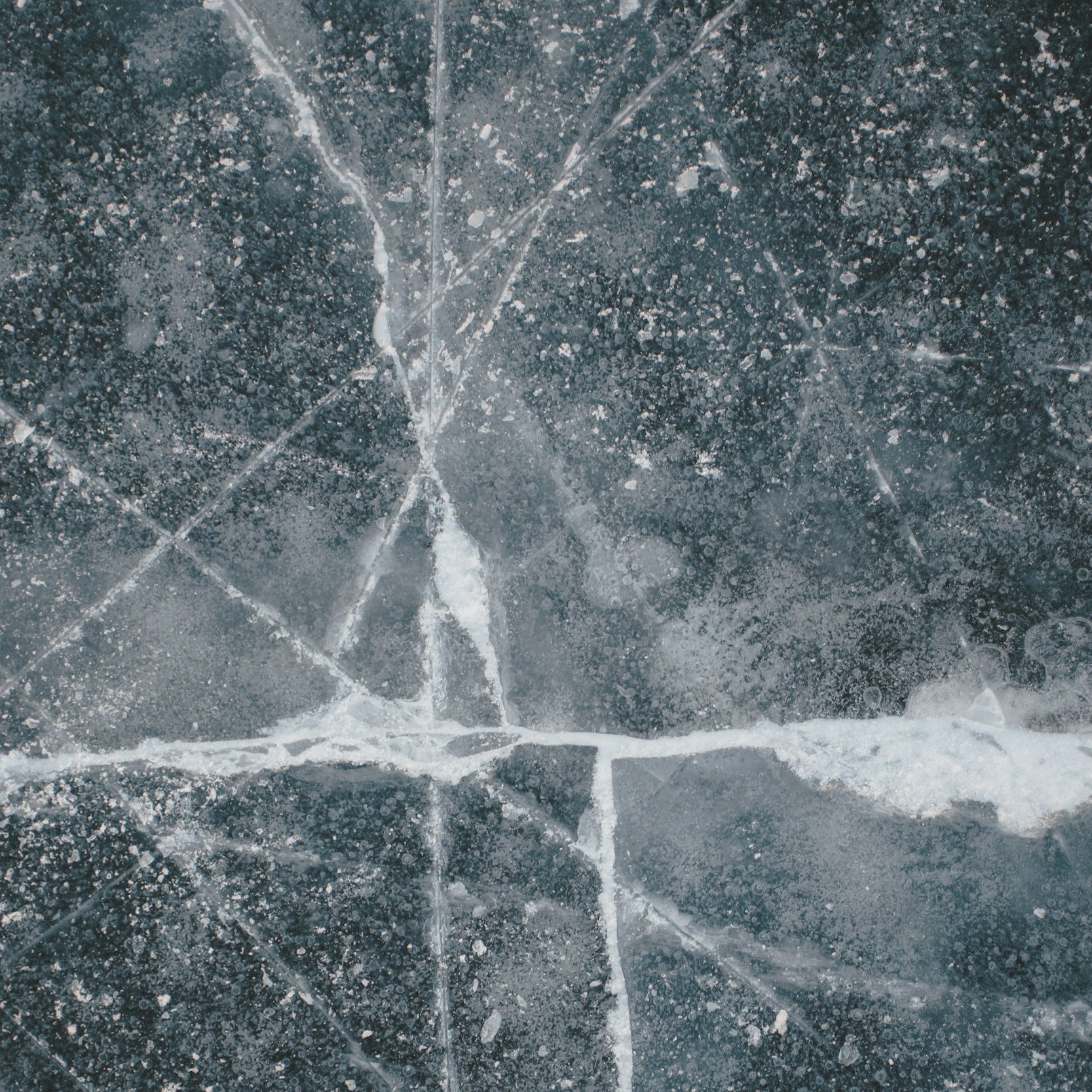 Close-up photo of cracked ice with visible white frost patterns and fractures.