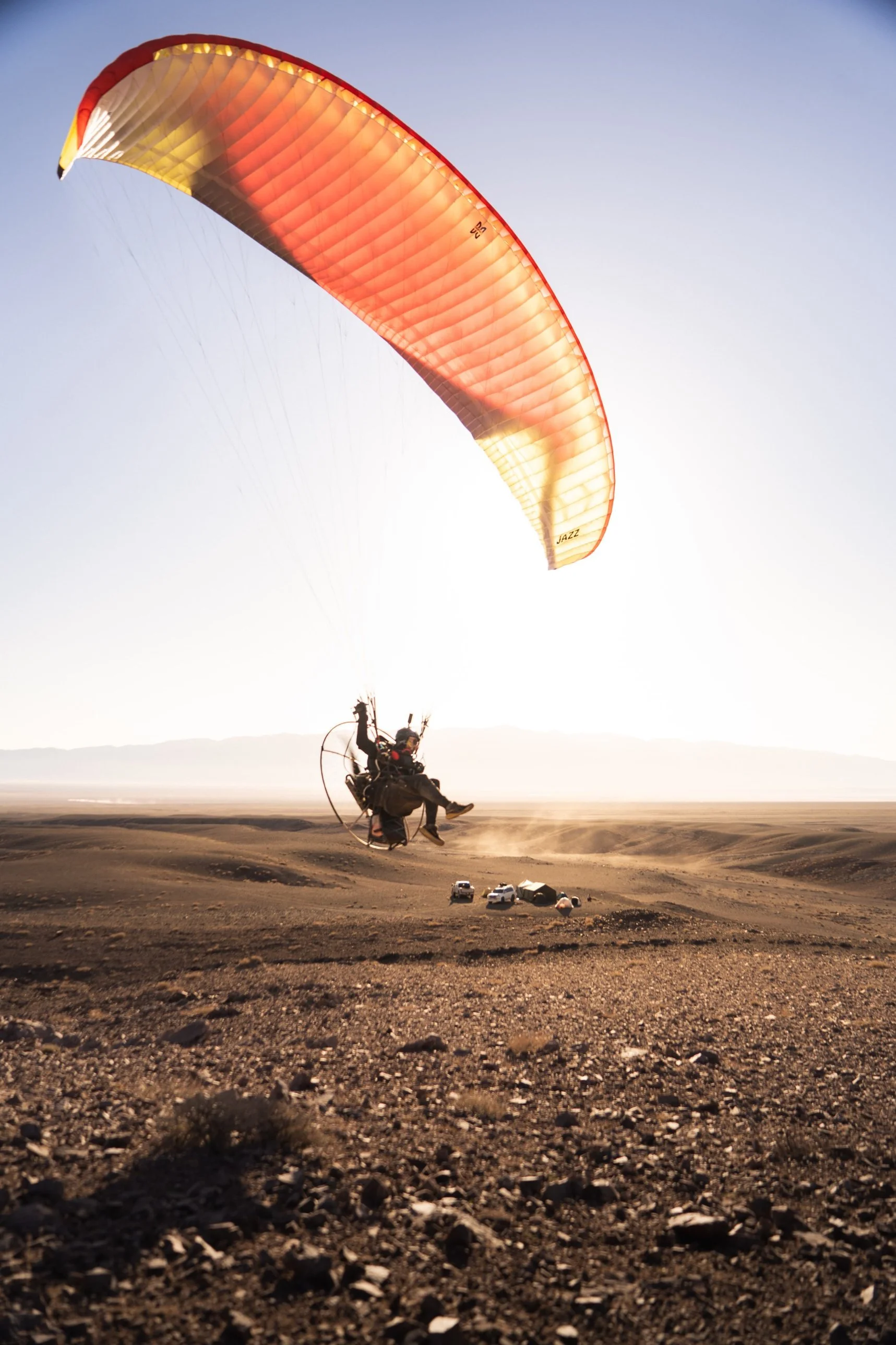 Paramotor pilot taking off beside the expedition camp in the Mongolian desert