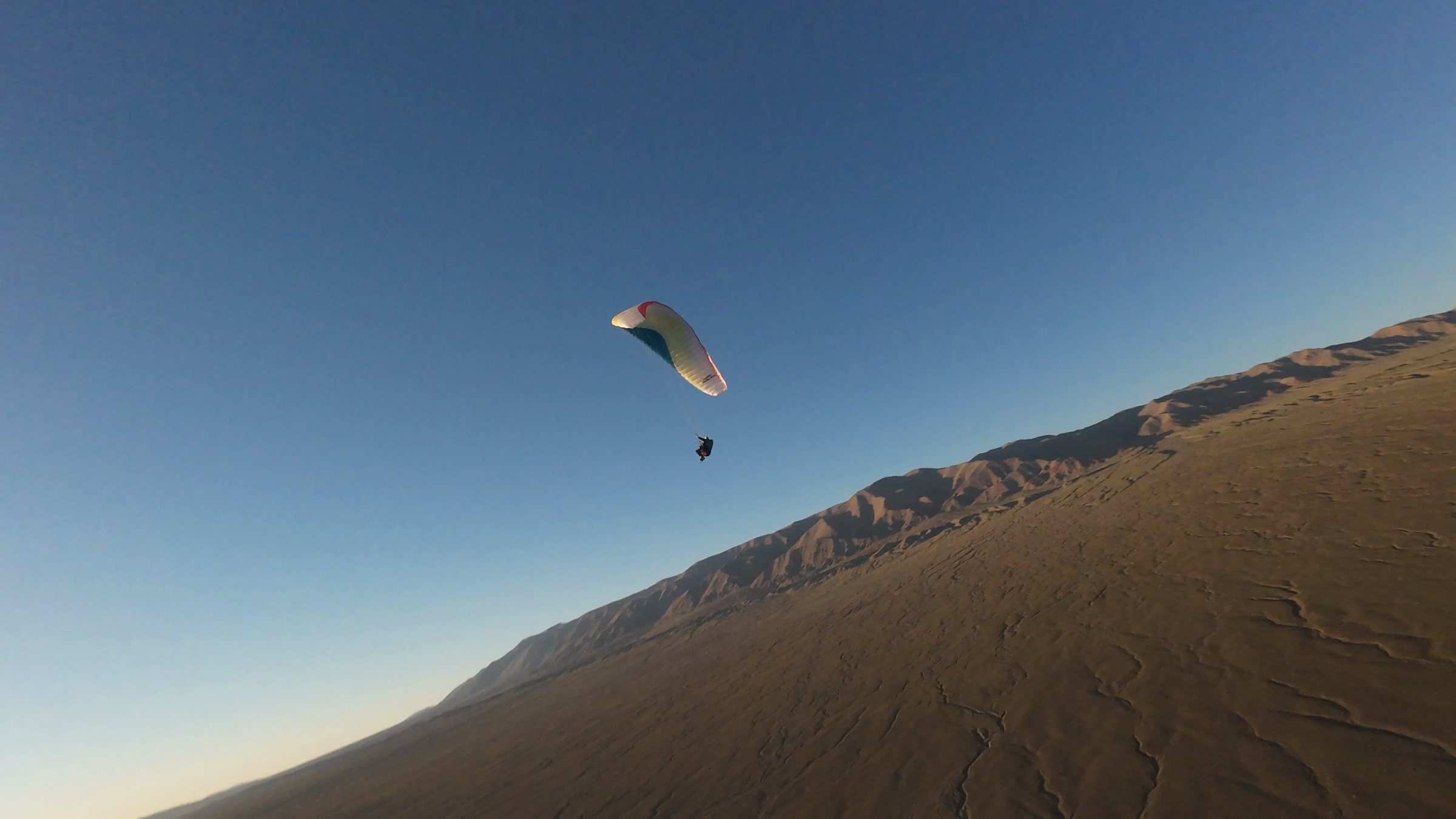 Paraglider flying at dusk near Ikh bogd mountain