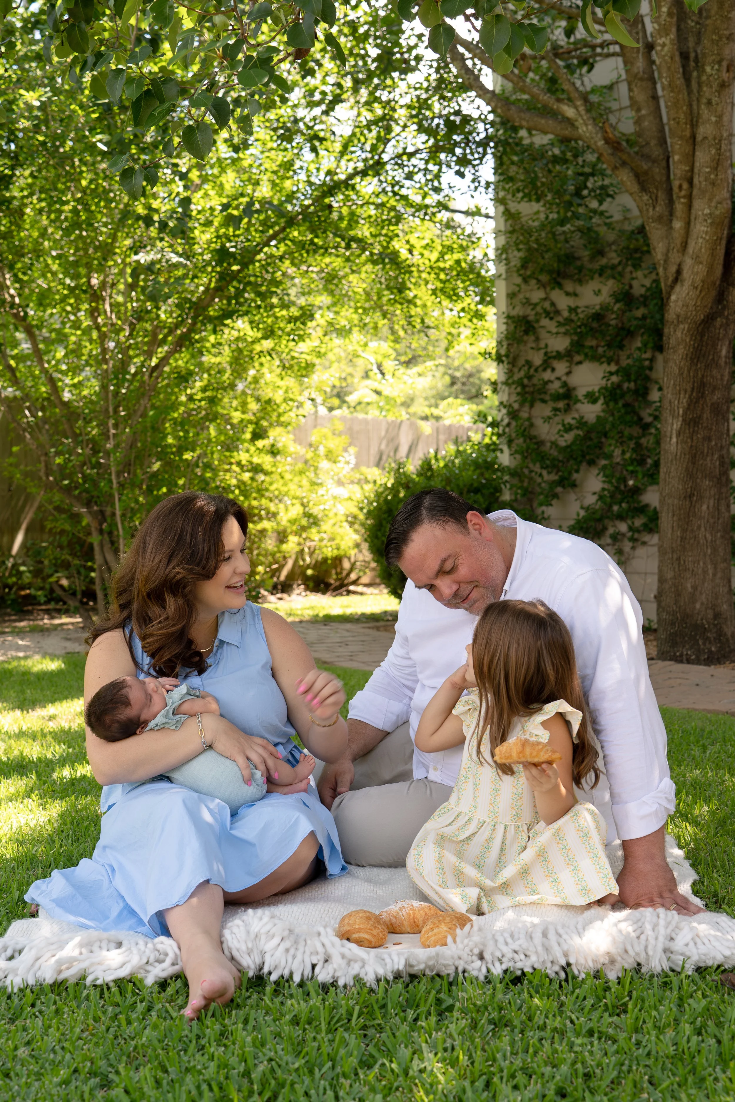 the woodlands & houston heights family with newborn outdoors eating croissants for a picnic