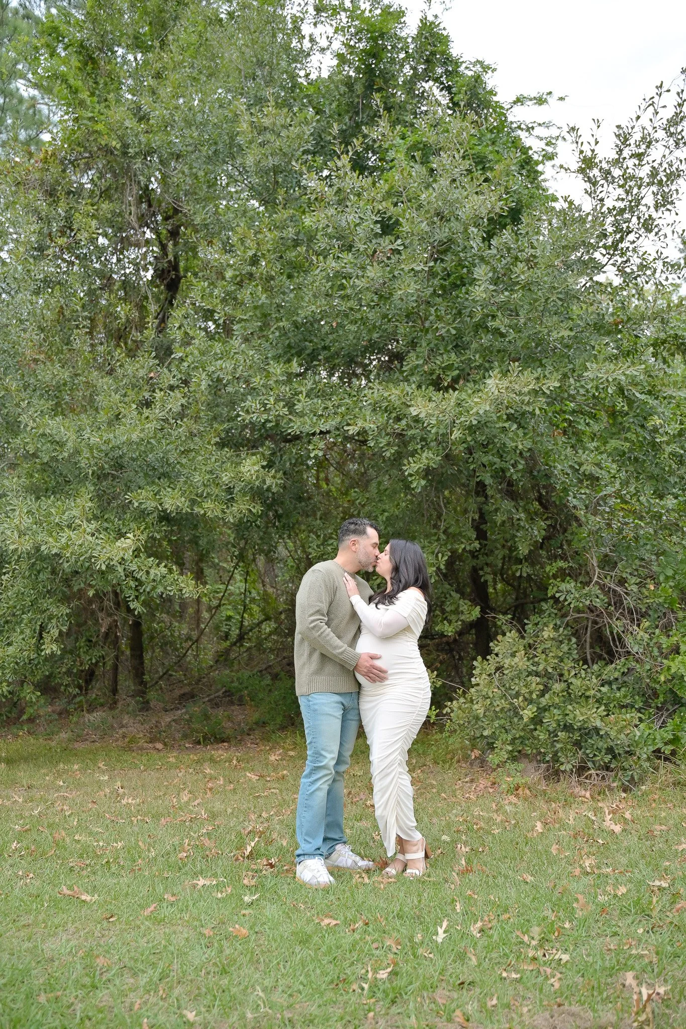 houston heights couple kissing in nature with pregnant belly showing