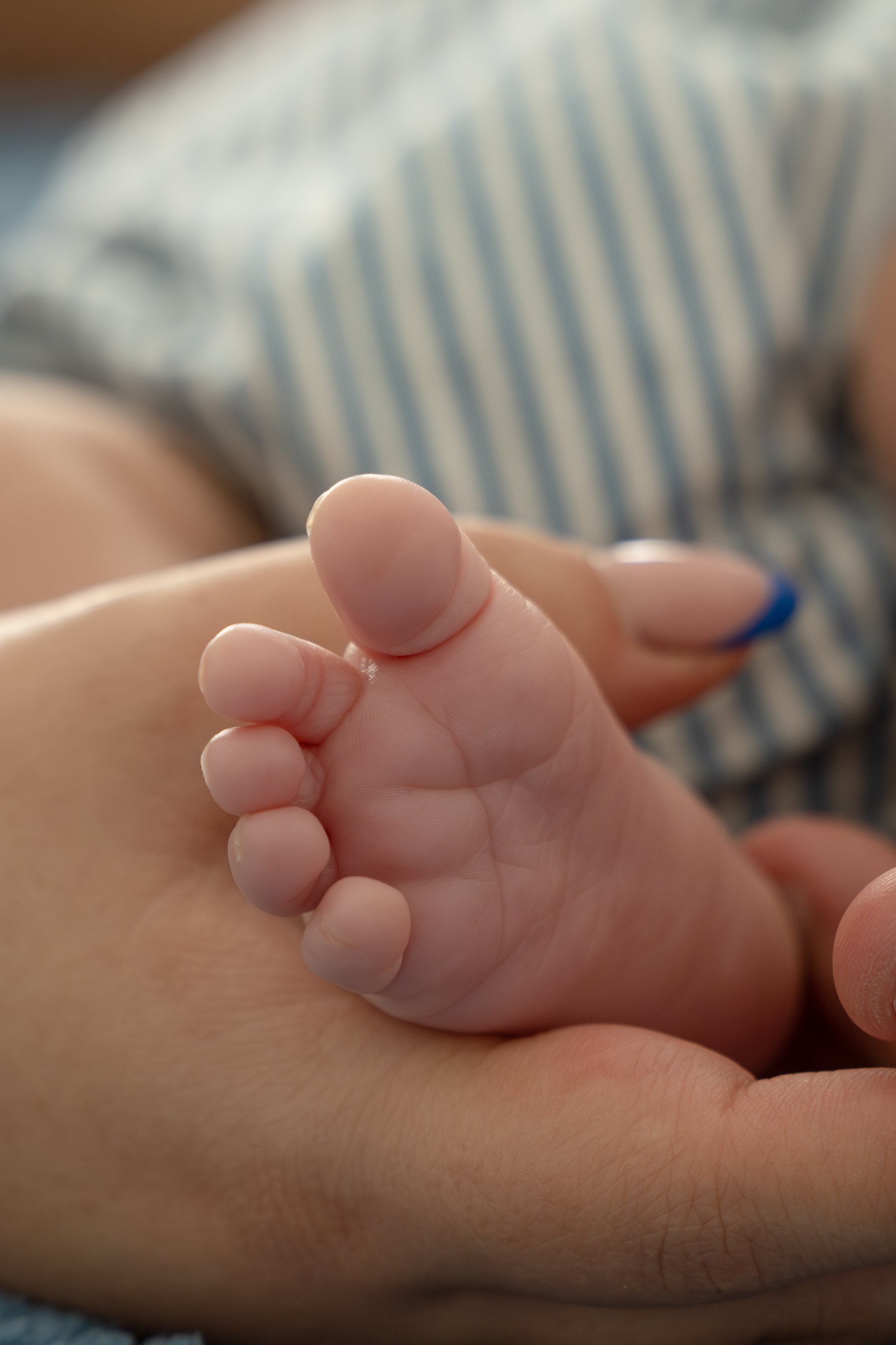 Close-up of a small hand with chubby fingers, grabbing another person's forearm, in their The Woodlands home.