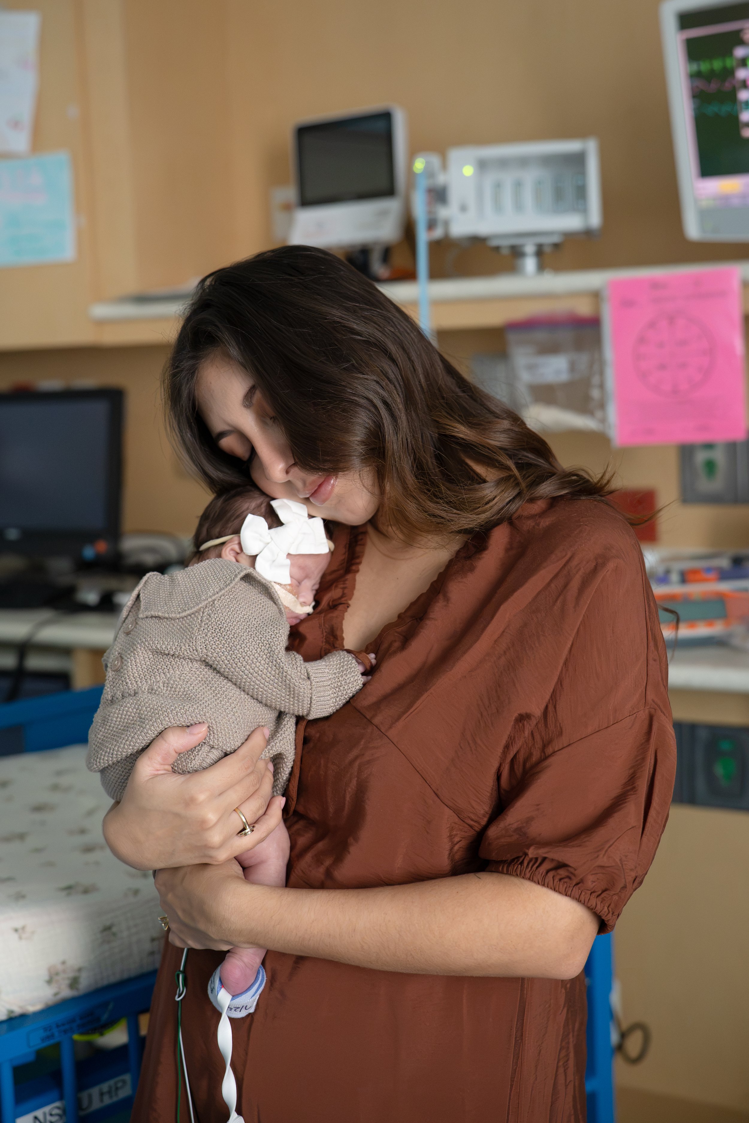 A woman holding a newborn baby in a hospital at Houston medical center.