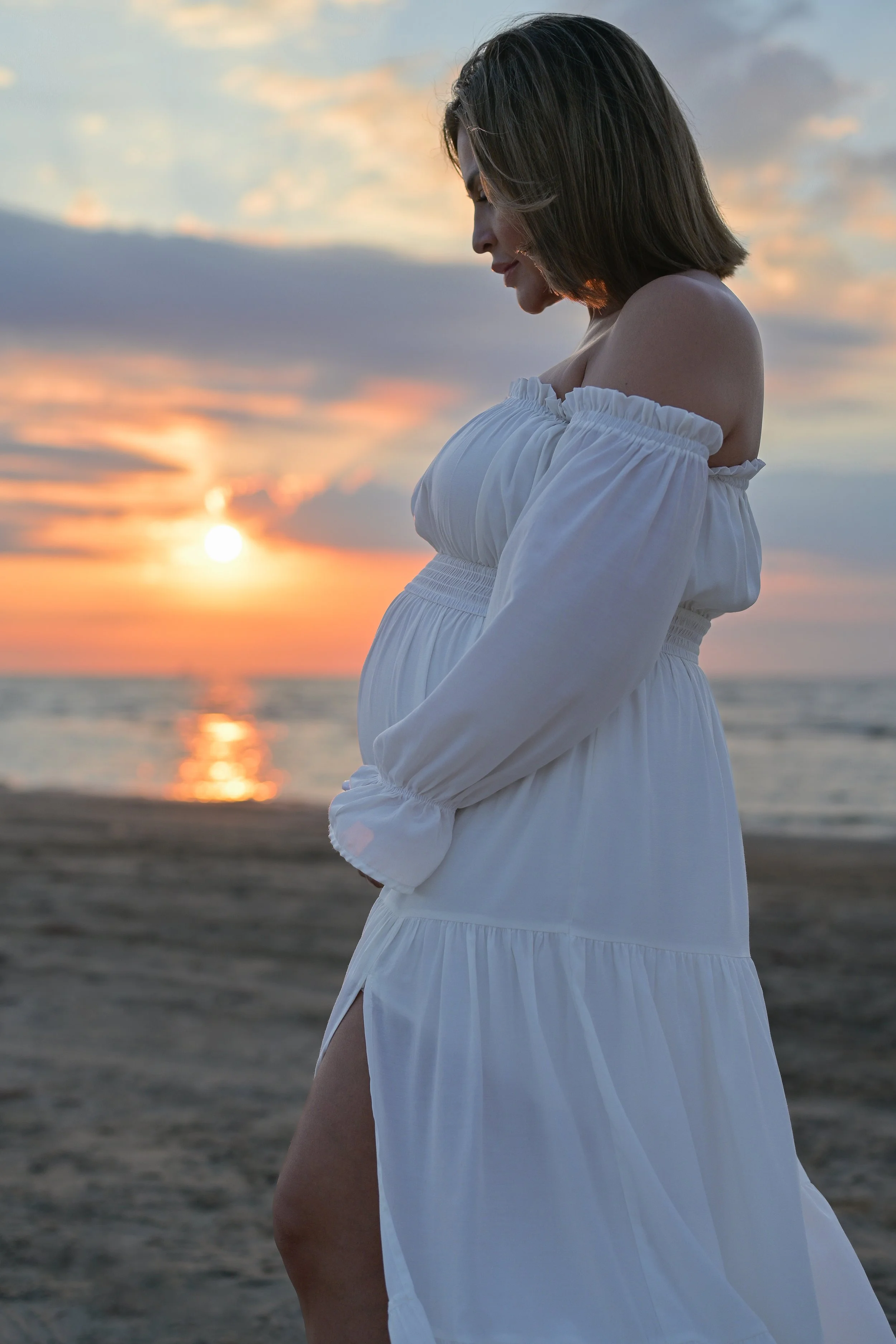 houston mom holding maternity belly during sunrise beach session