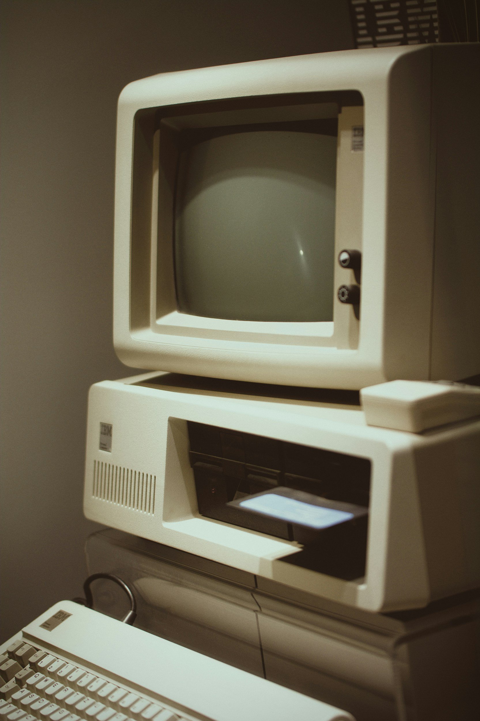A vintage Macintosh computer setup with a CRT monitor and a keyboard.