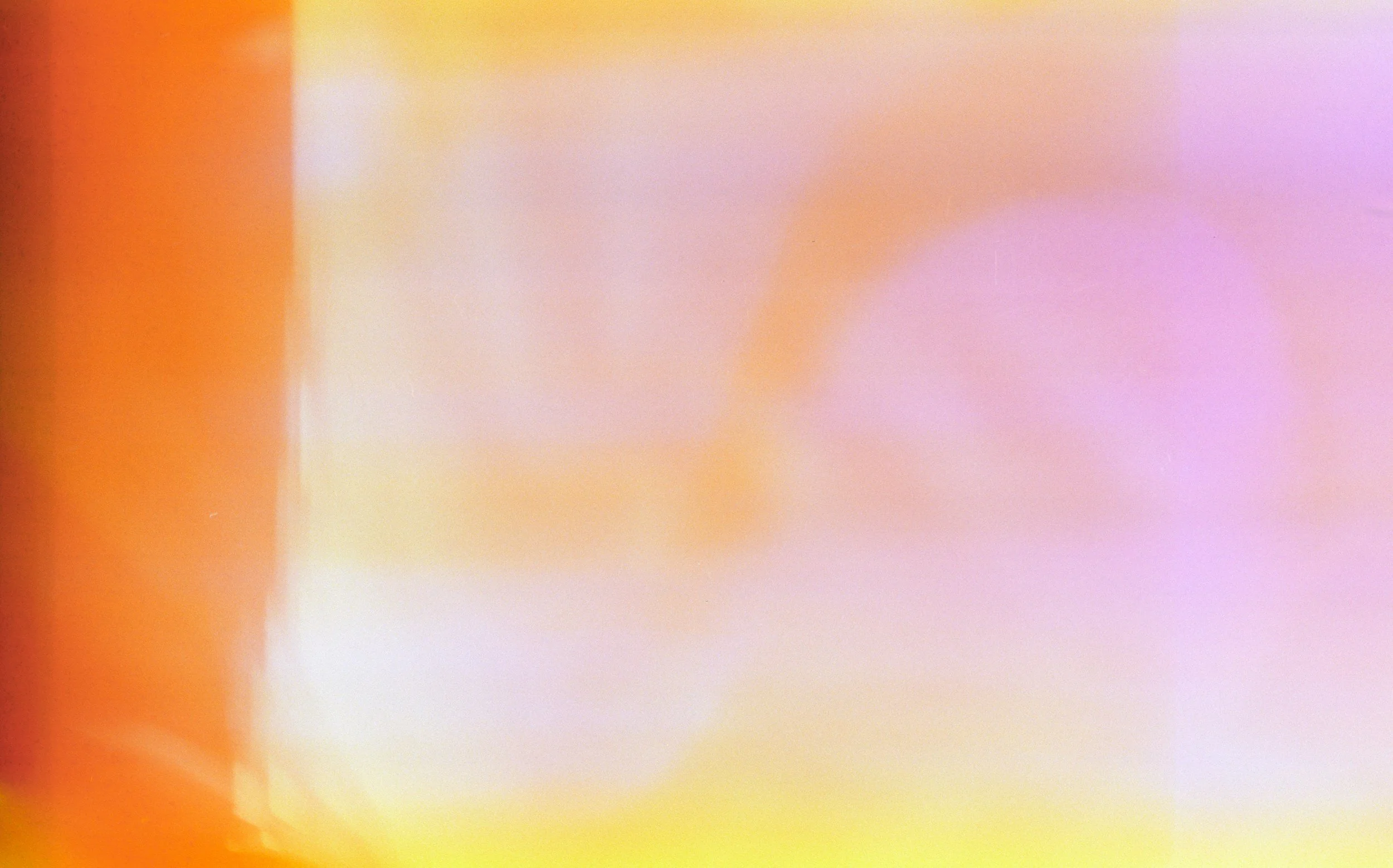 Abstract colorful blurred pattern with shades of orange, pink, purple, yellow, and white.