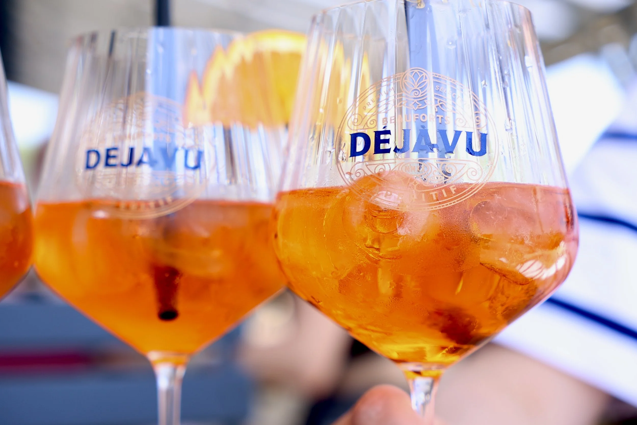 Bunte Aperol Spritz Cocktails in weißen Weingläsern mit Orangenscheiben und Eis