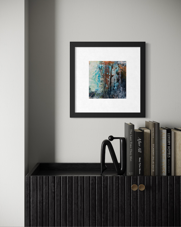 Interior scene with a black cabinet, a black modern sculpture, a small stack of books, and a framed abstract painting on a white wall.