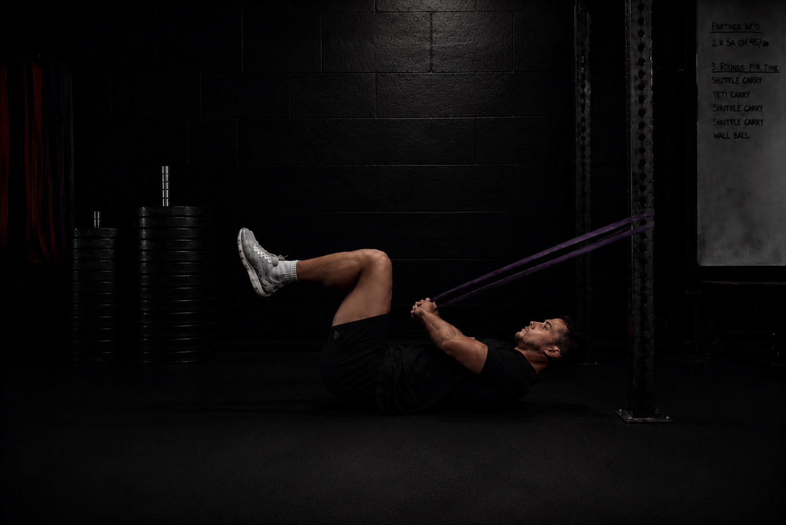 Performance coach guiding a band-resisted core exercise to develop trunk control, pelvic stability, and spinal position in London.