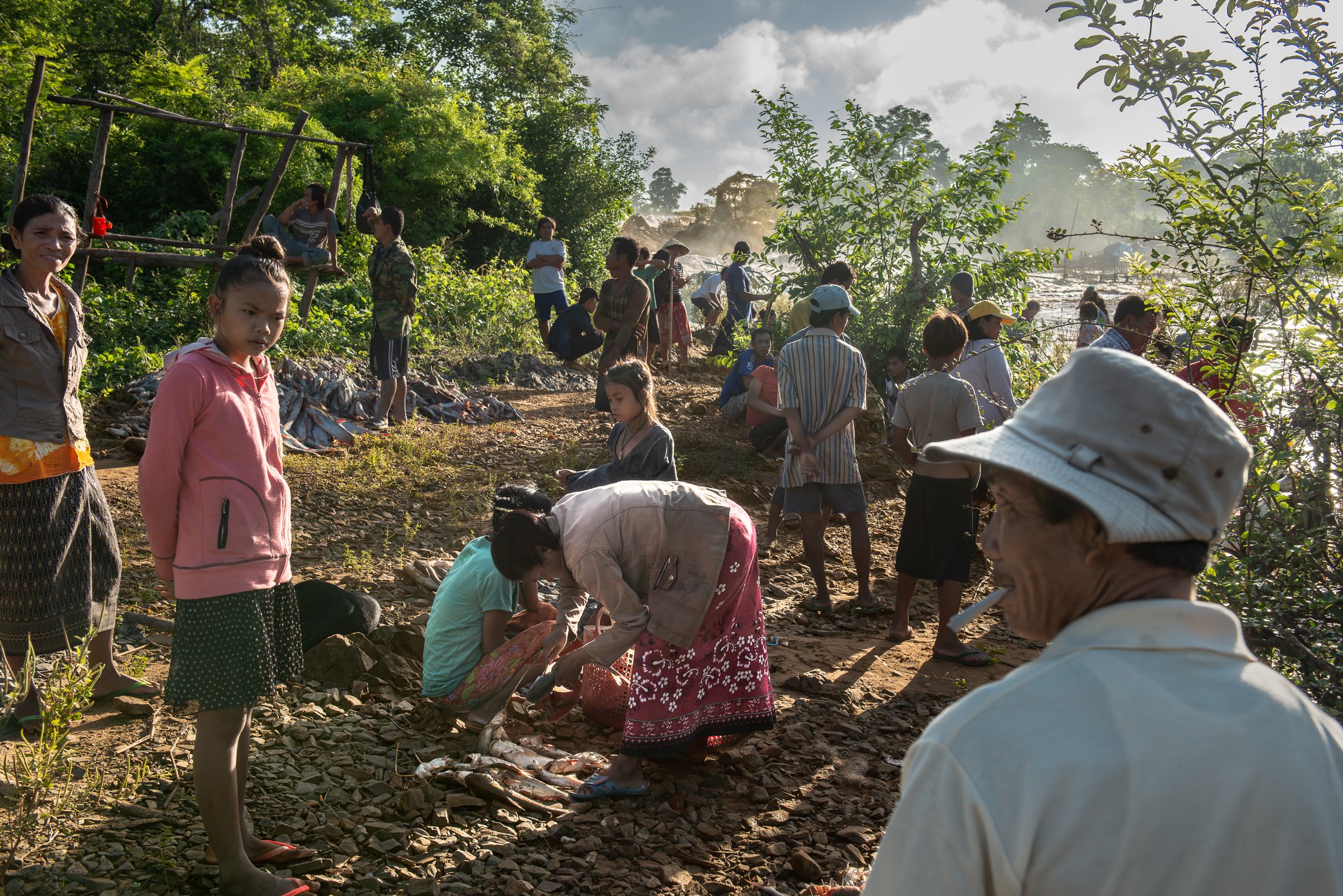At first light in Si Phan Don, families and neighbors gather near the Li trap sites as fish from the night’s catch are divided. Some have come to receive a share from the trap owner; others are relatives of the fishermen, collecting the portion set a