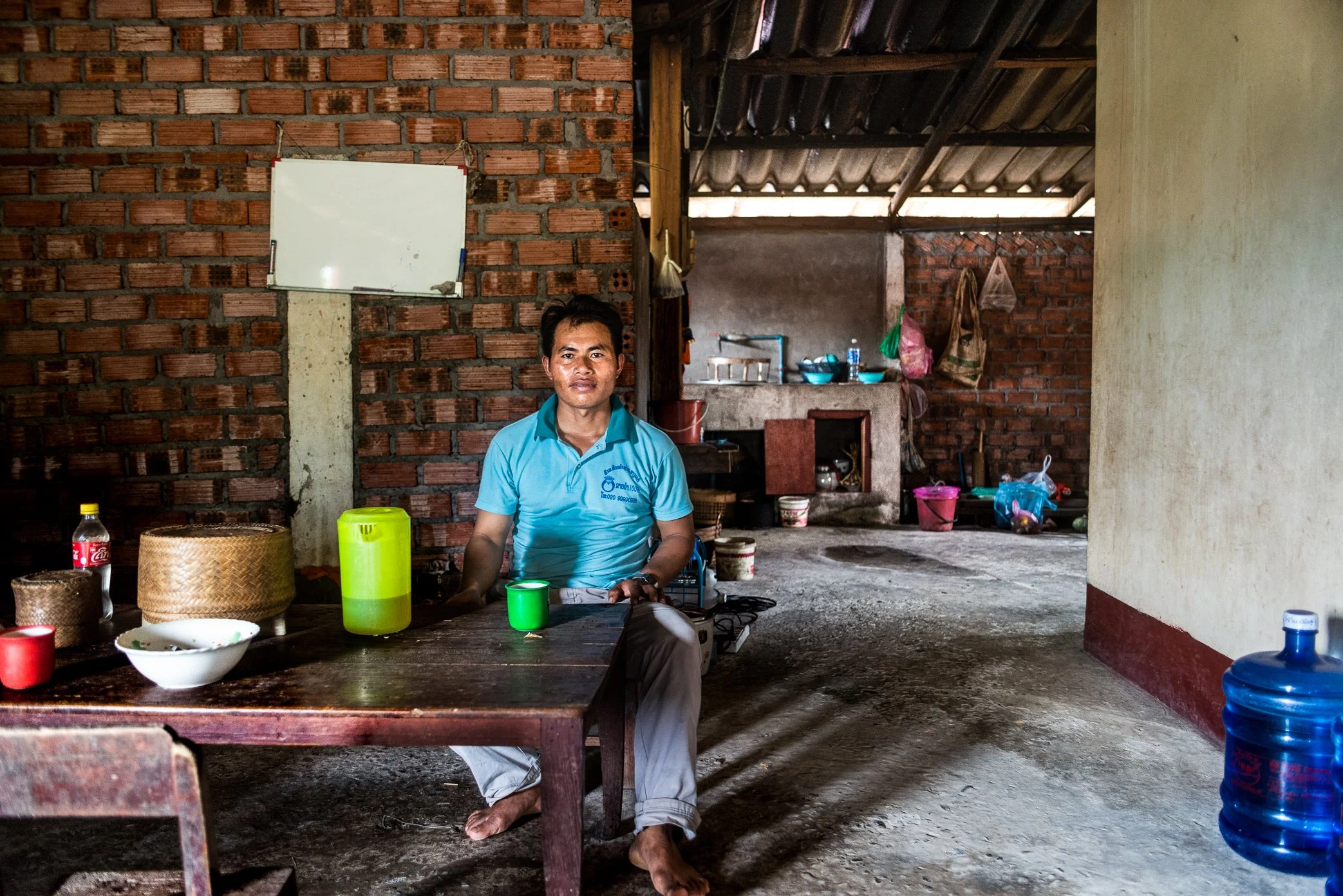 A villager sits inside the house he received as compensation after his former home was submerged by the Nam Ou 1 hydropower project in Pak Ou District, Luang Prabang. Official reports noted that affected families from the project were resettled as co
