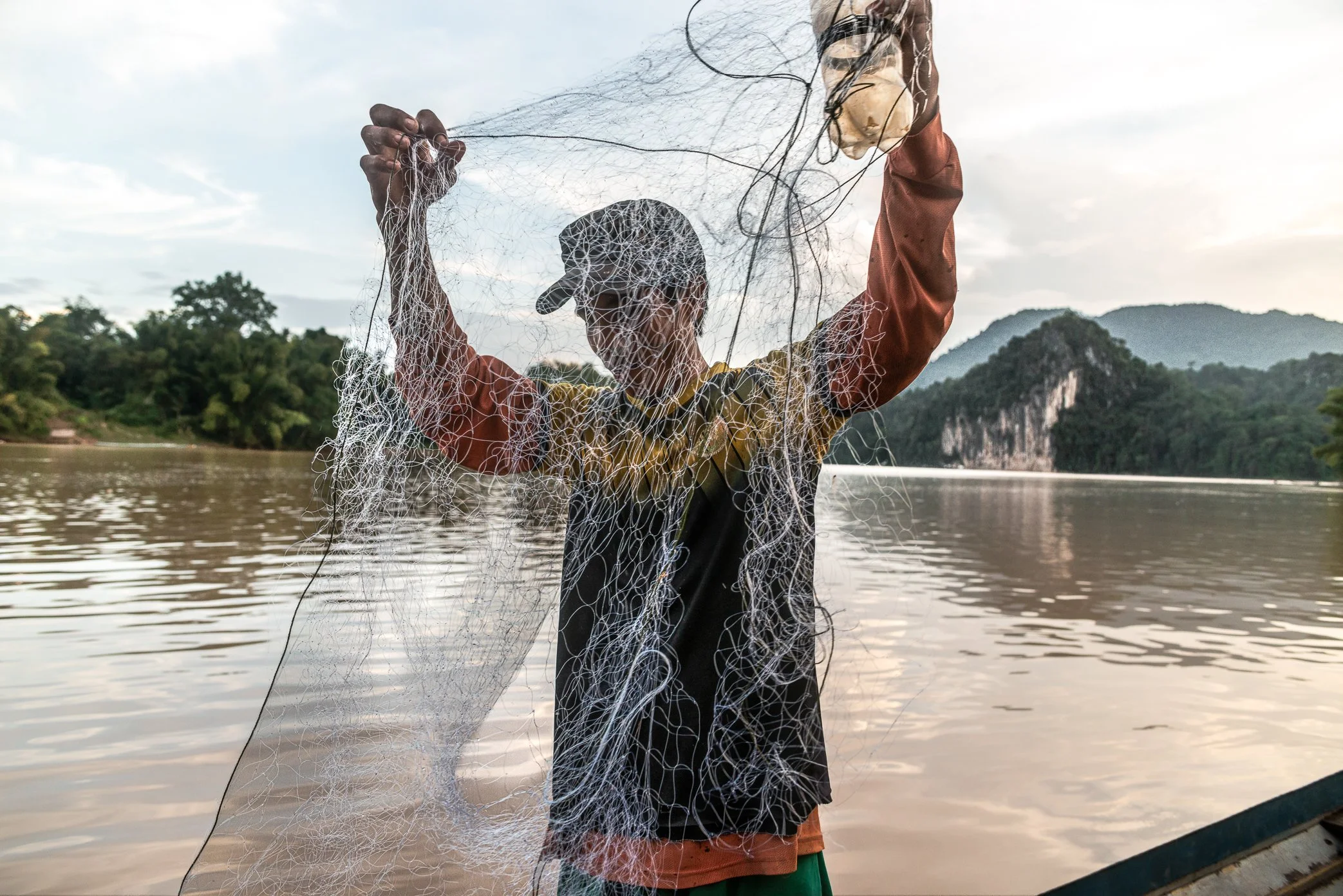 A fisherman from Pak Nam Ou village untangles his net near the confluence of the Nam Ou and Mekong rivers, where local families have depended on fishing for generations.

For villagers here, the river has long provided both food and income. But in re