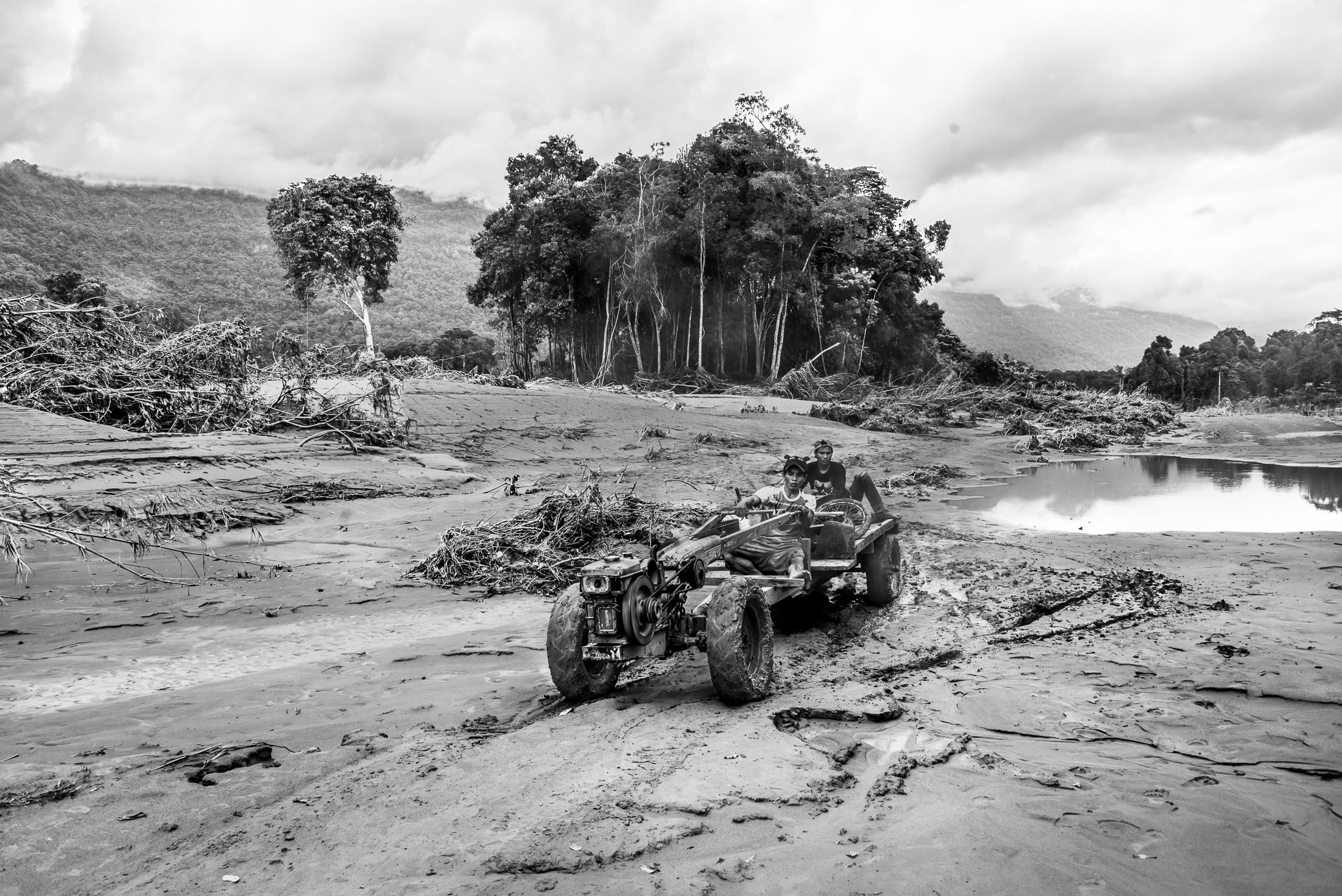 Hin Lat Village, Attapeu, Laos - Villagers travel along what was once the main road through Hin Lat after the Xe Pian dam collapse. Before the disaster, homes stood on both sides of this road as it cut through the center of the village. After the flo