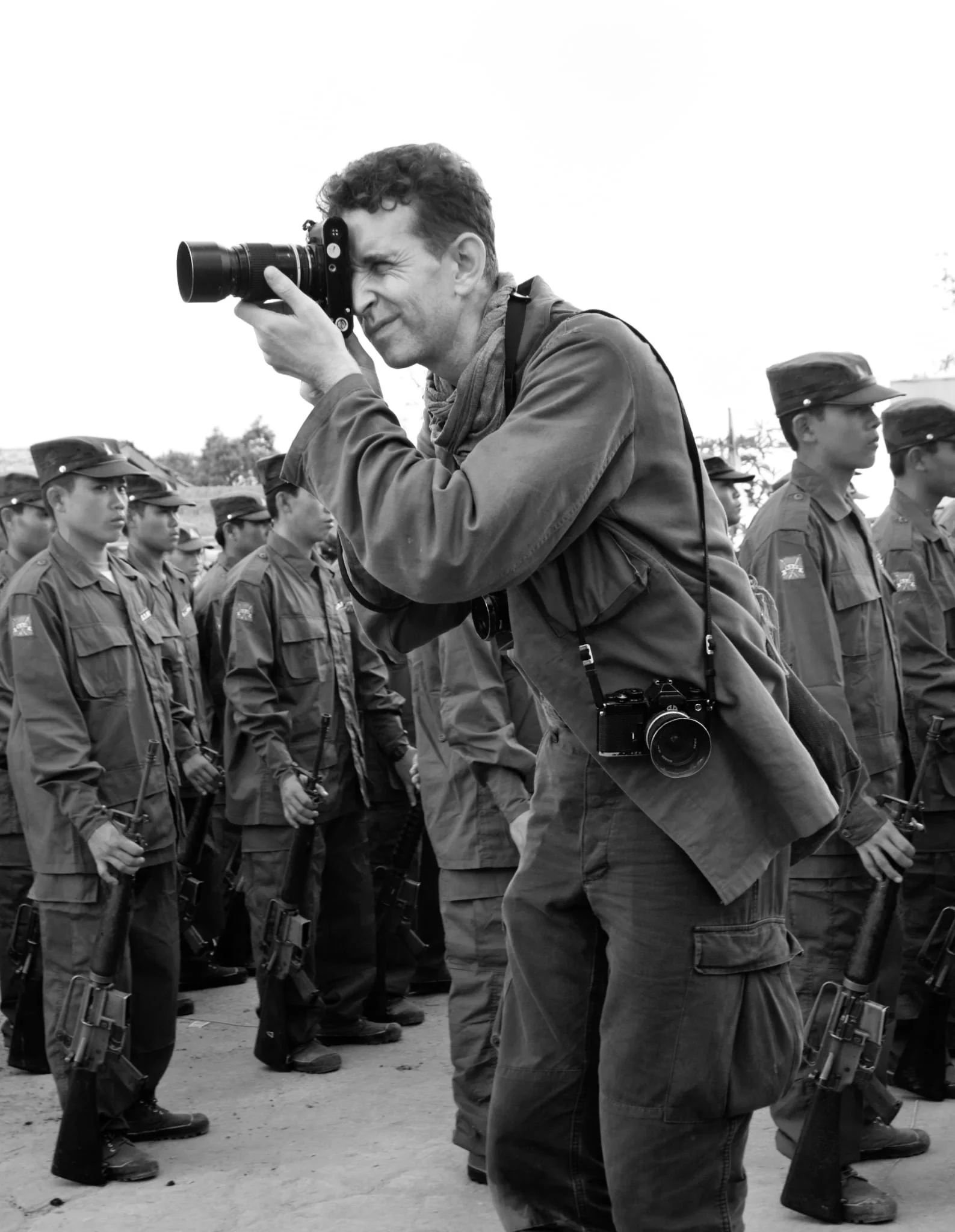 Photographer taking picture of a line of soldiers in uniform.