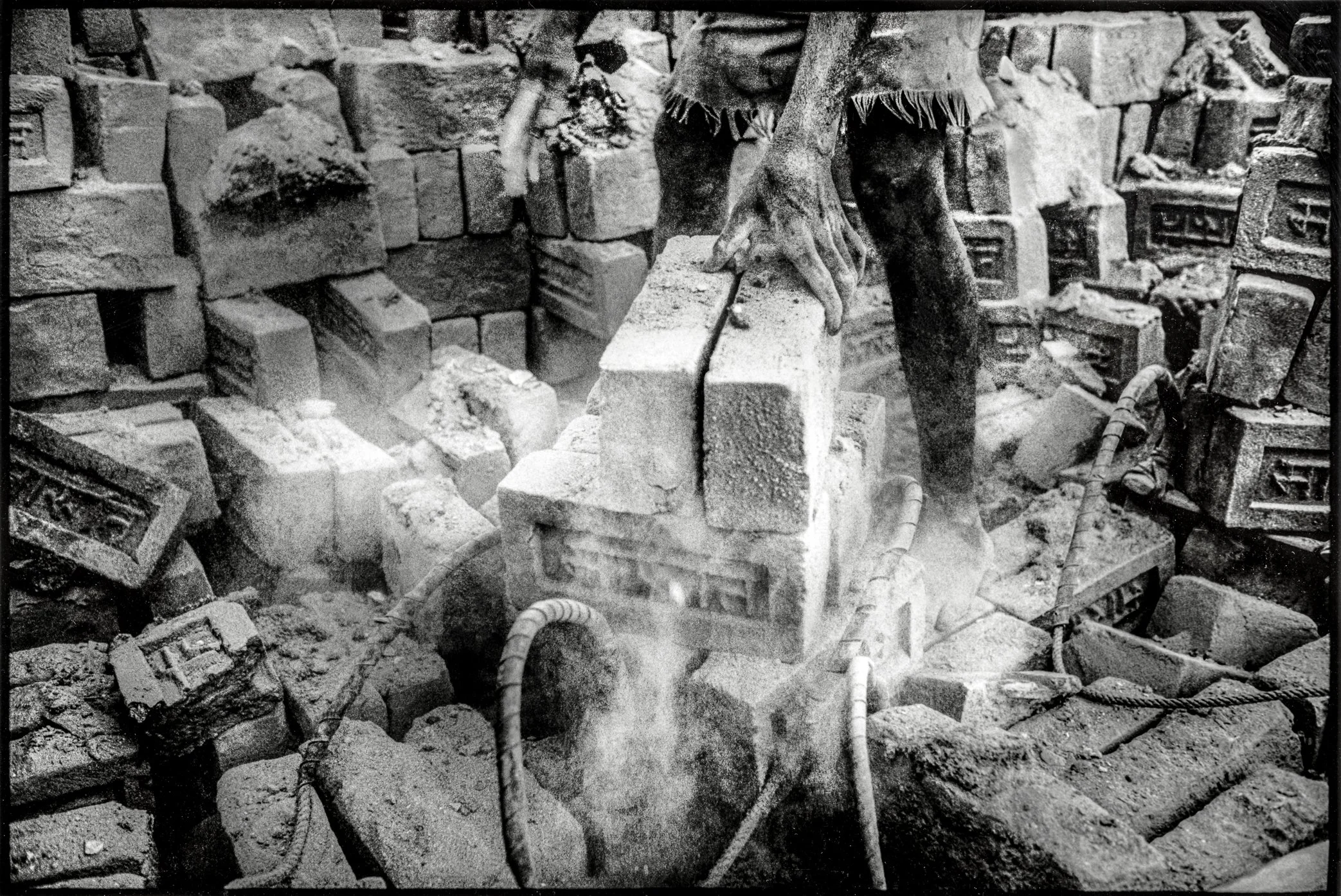 Patna, Bihar, India, April 2003 - Dust rises as fired bricks are lifted and stacked for transport. At the kiln, every movement sends clay and ash back into the air, turning the final stage of production into another layer of exposure for the workers.