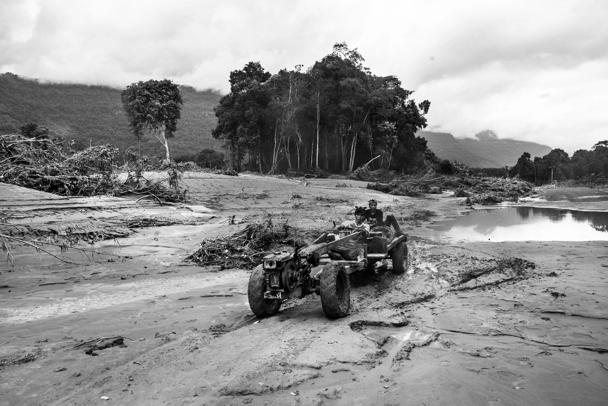 Hin Lat Village, Attapeu, Laos - Villagers travel along what was once the main road through Hin Lat after the Xe Pian dam collapse. Before the disaster, homes stood on both sides of this road as it cut through the center of the village. After the flo