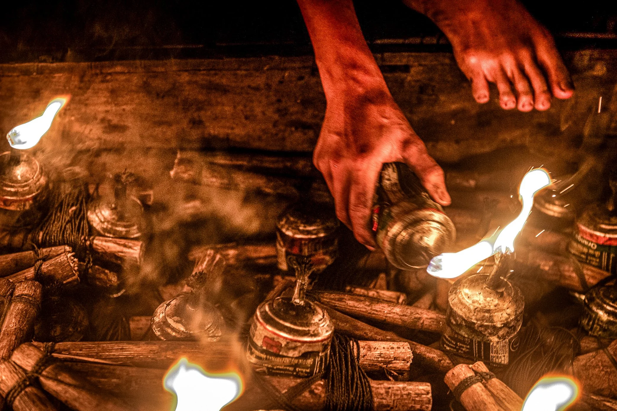 Tonle Sap, Cambodia - A fisherman fills oil lamps used to attract fish during night fishing on the Tonle Sap. Each lamp burns kerosene, casting light across the dark water to draw insects and fish toward the boat. But every night, dozens of boats usi