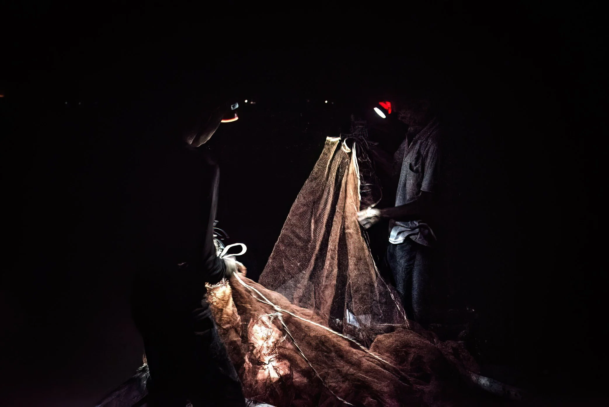 Tonle Sap, Cambodia - At the end of the night, every net is folded, every piece of gear hidden and kept in order for the next return to the lake. On Tonle Sap, survival is not improvised; it is repeated with care, night after night, inside a fragile 