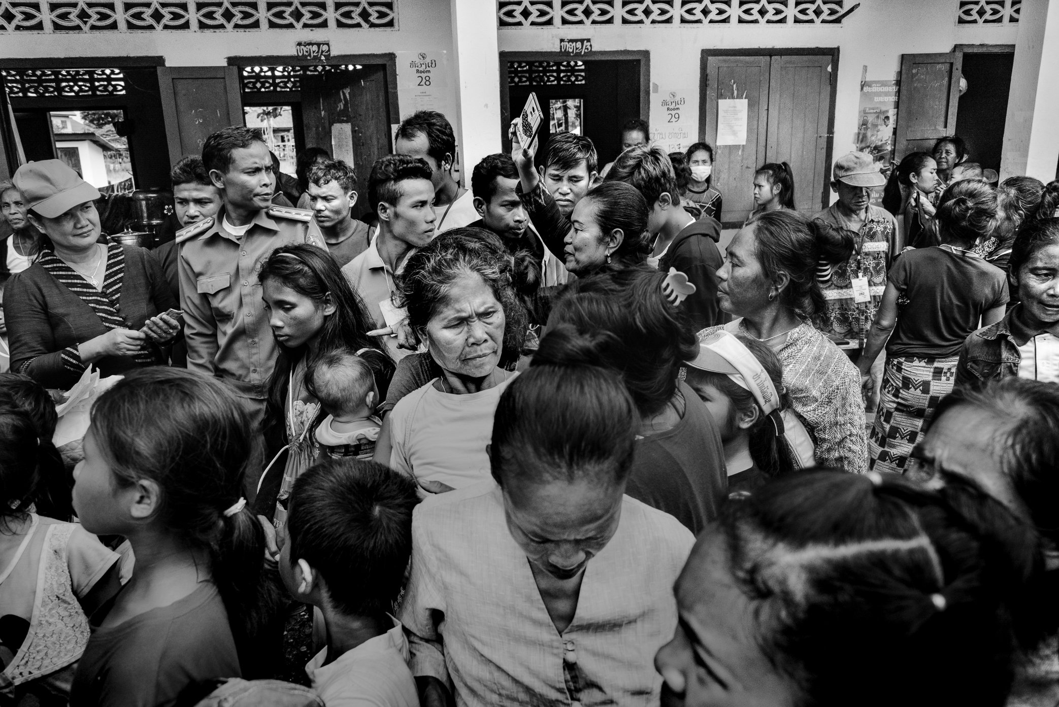 Sanamxai, Attapeu, Laos - Tension rises among survivors living in a temporary shelter at Sanamxai School after the Xe Pian dam collapse. Displaced families crowd the school corridors, waiting for information, assistance, and news of relatives still m