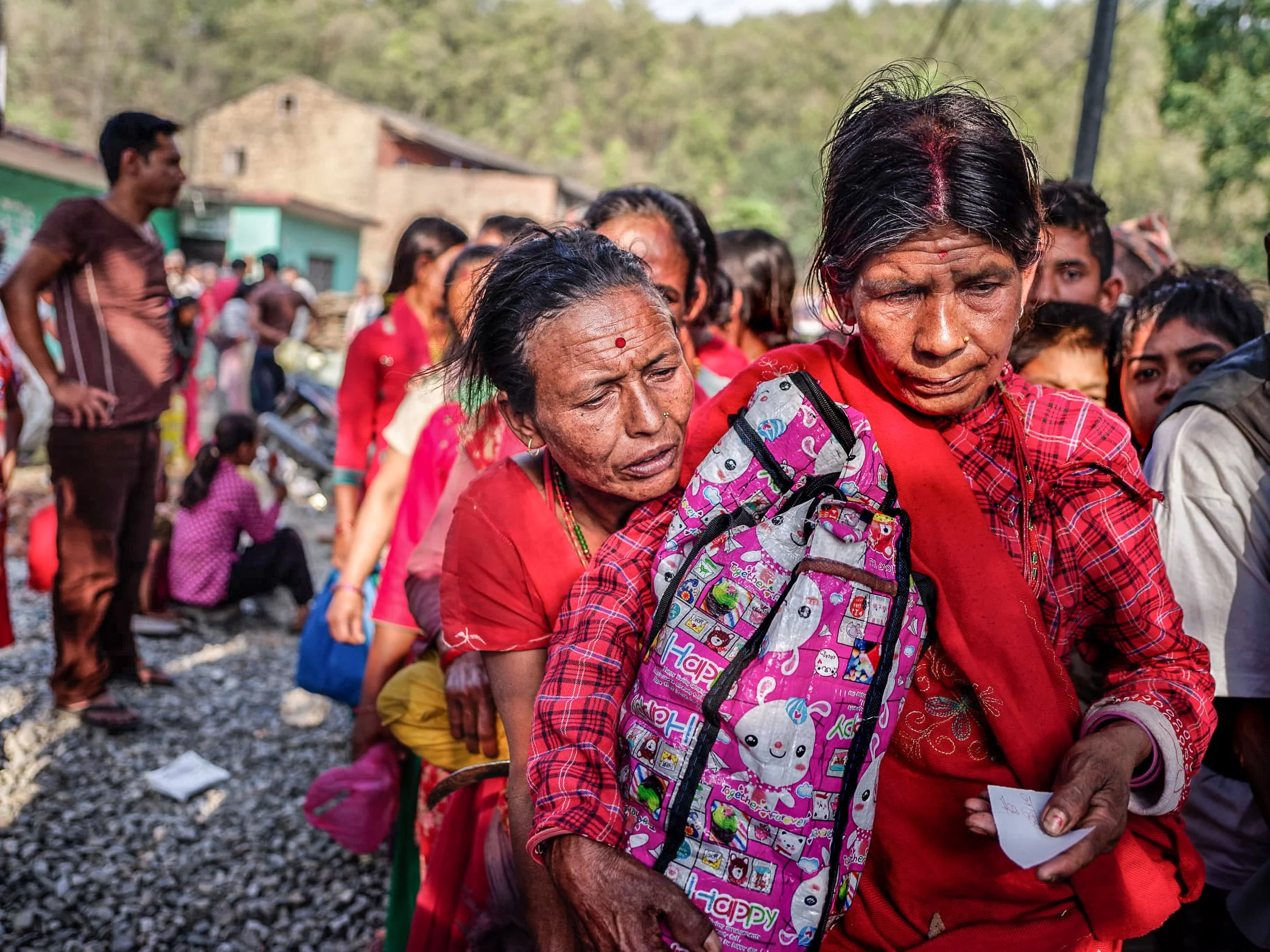 Women wait in line for relief supplies after the 2015 Nepal earthquake, their faces marked by exhaustion and uncertainty. Along the road toward Dhading District, one of the severely affected areas outside Kathmandu, aid distribution became a matter o
