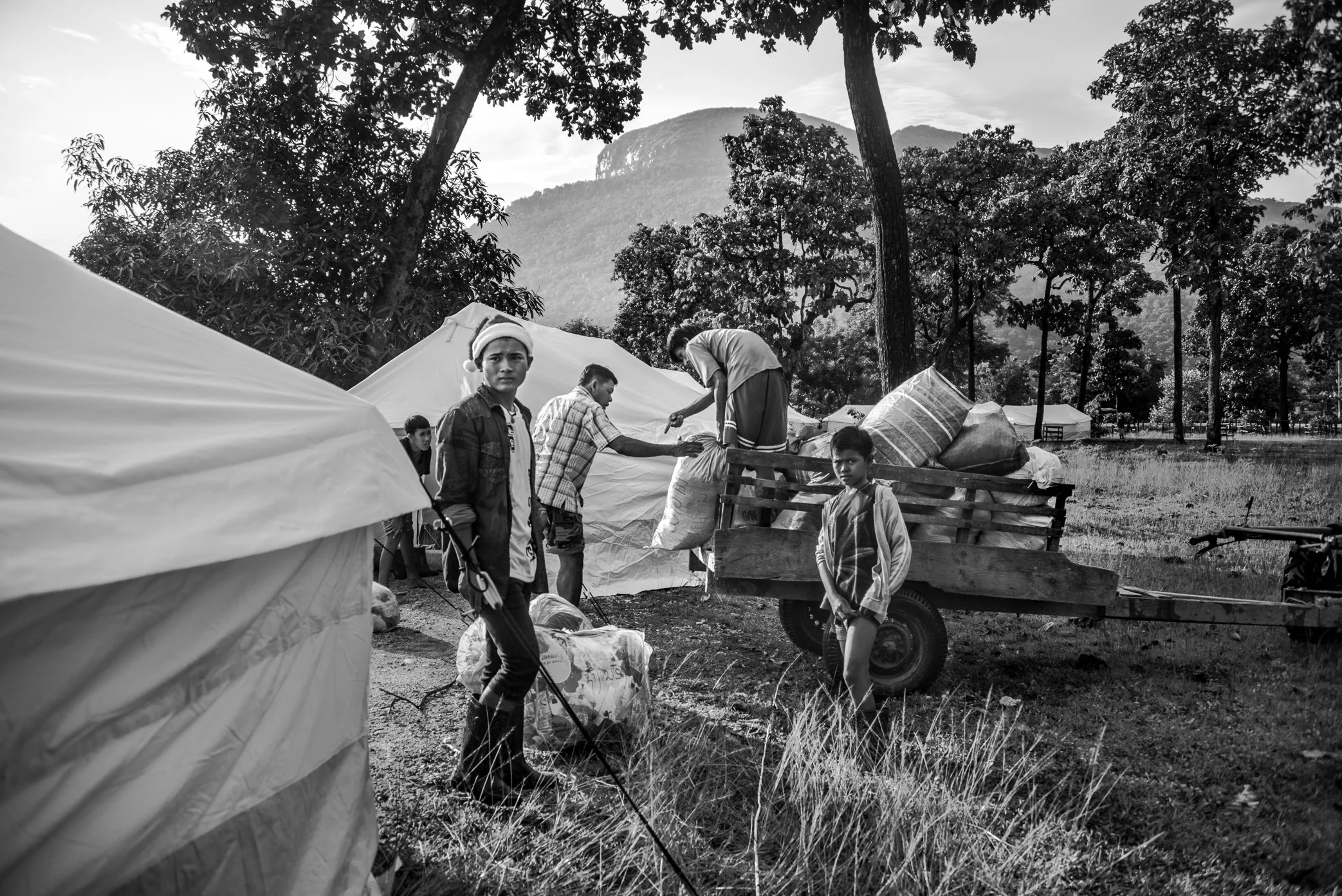 Sanamxai, Attapeu, Laos - Survivors of the Xe Pian dam collapse move their belongings from overcrowded school buildings into newly supplied tents at the Sanamxai shelter. For displaced families, the tents offered more space, but not yet a return to h
