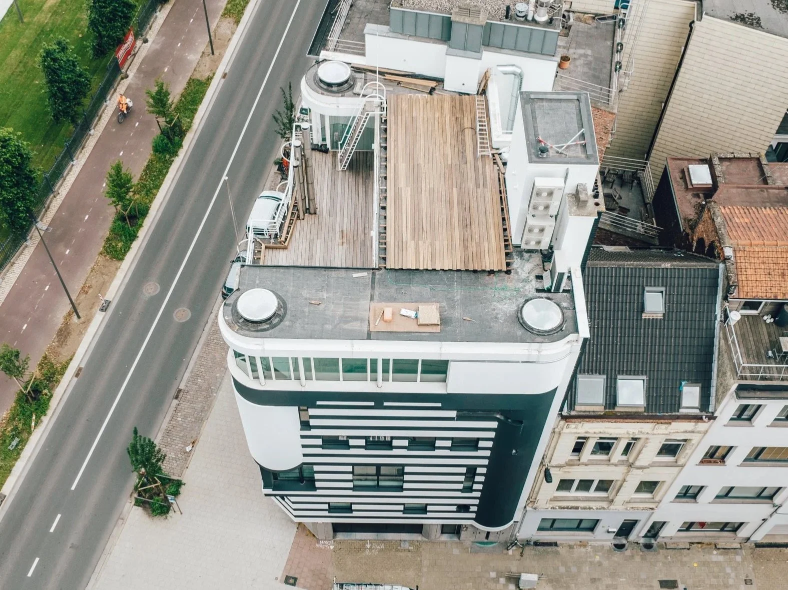 Luchtfoto van het Huis van Roosmalen een plat dak, waarin delen worden gerenoveerd of verbouwd, zichtbaar is bouwmateriaal en een houten vloer op het dak.