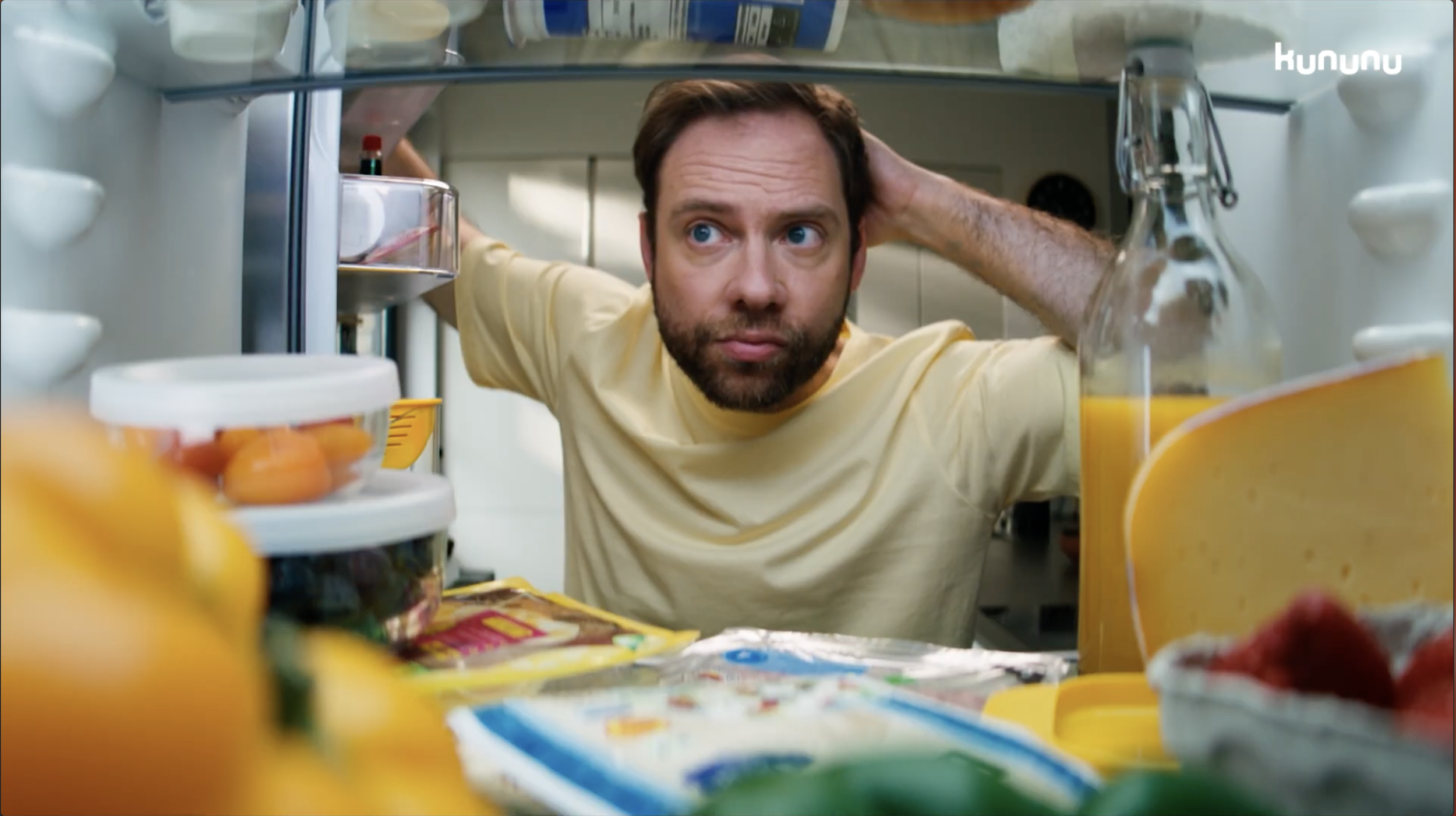 Mann schaut in den Kühlschrank, um Lebensmittel zu überprüfen.