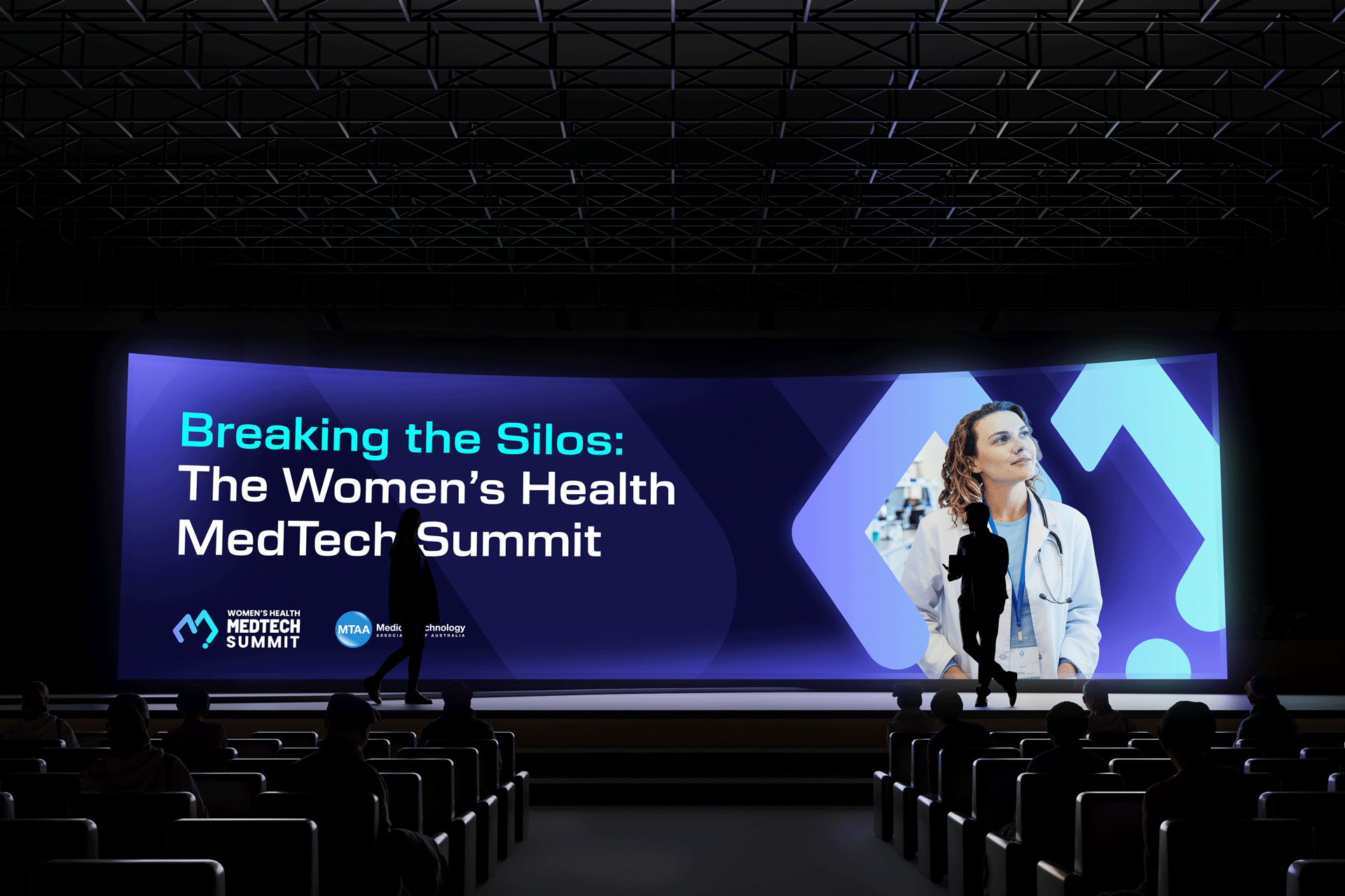 Large digital screen at a conference displaying the title "Breaking the Silos: The Women's Health MedTech Summit" with logos of Women's Health MedTech Summit and MTAA. Two silhouetted speakers walk across the stage, and an audience is seated in front.