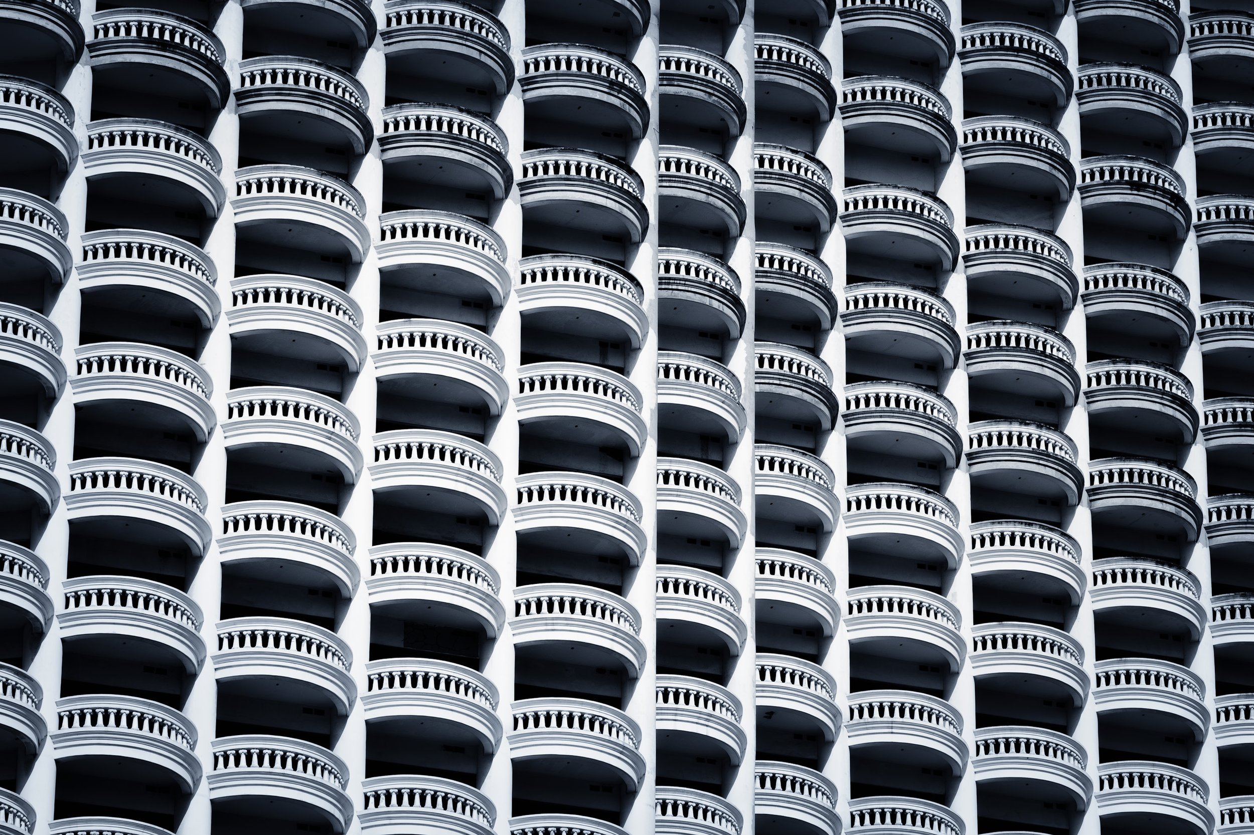 Close-up of the exterior of a high-rise building with multiple repeating balconies arranged in a grid pattern.
