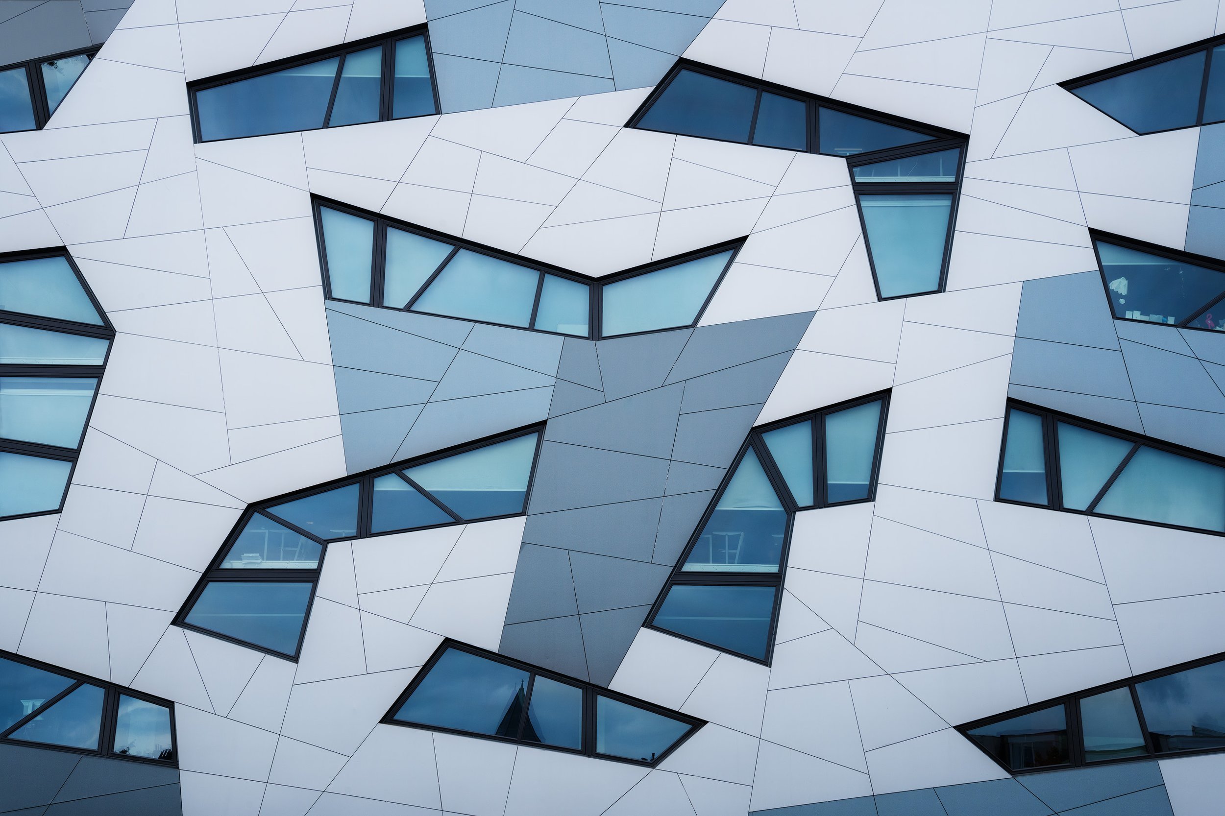 Modern building with geometric, angular panels and multiple windows.