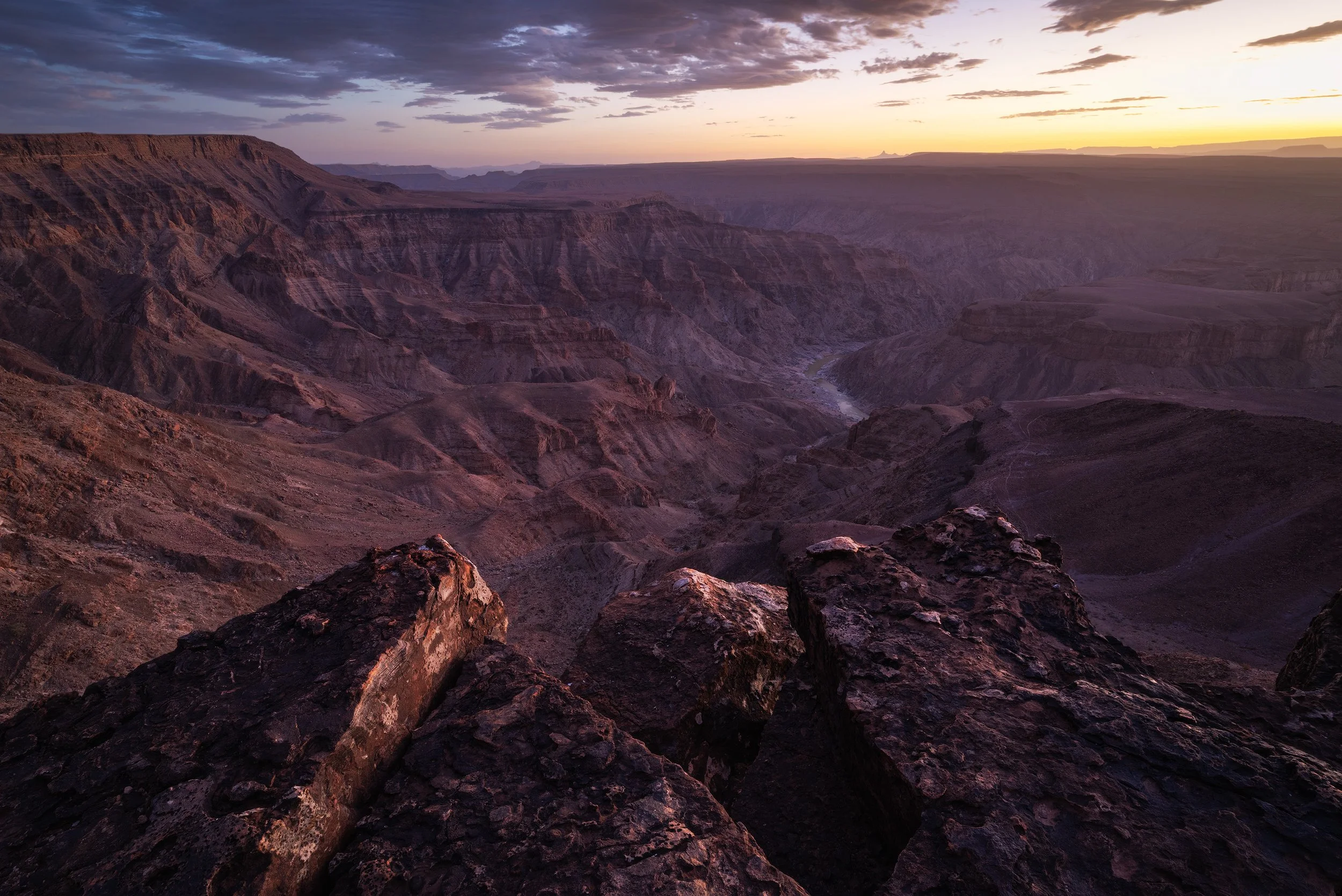Sunset over the fish river canyon, Namibia, with rocky foreground and expansive canyon view