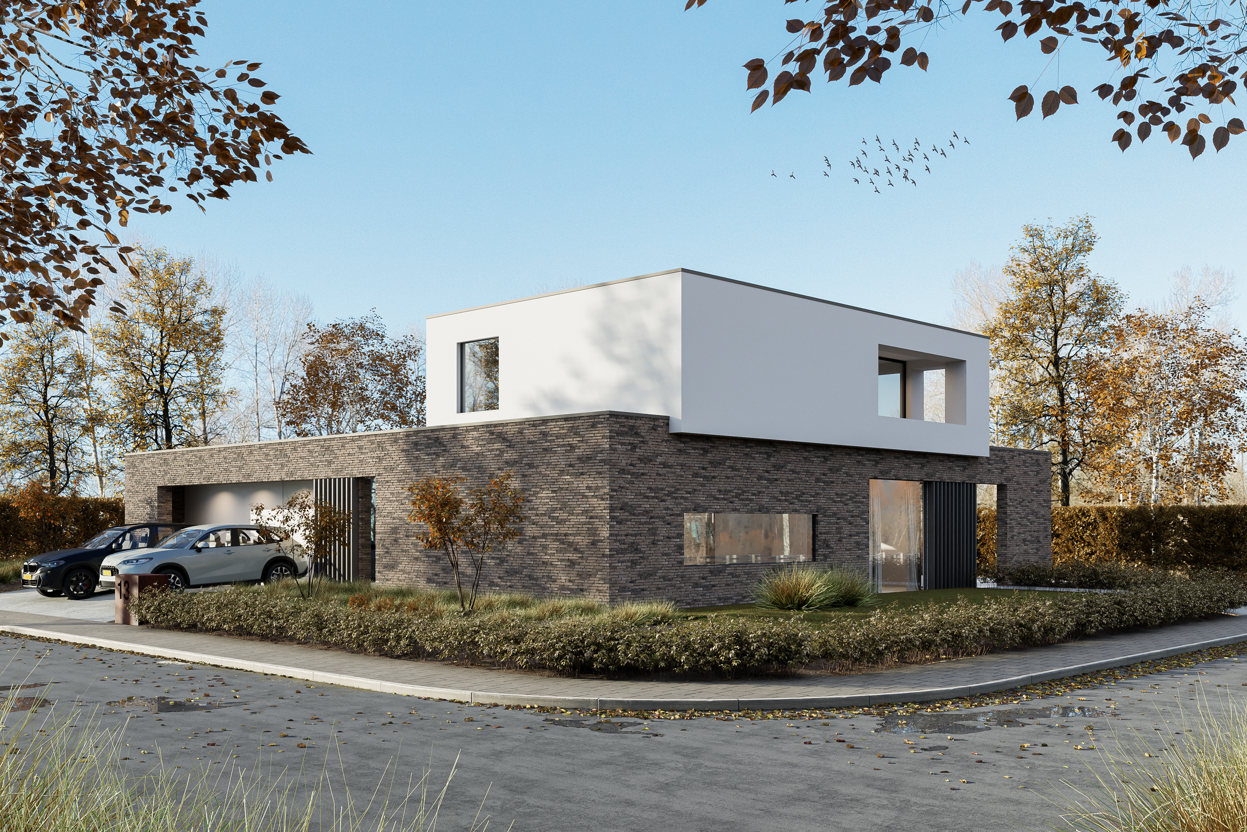 Moderne witte en bakstenen gebouw met grote ramen, omgeven door herfstbomen met geel en bruin blad, onder een blauwe lucht met zwerm vogels.