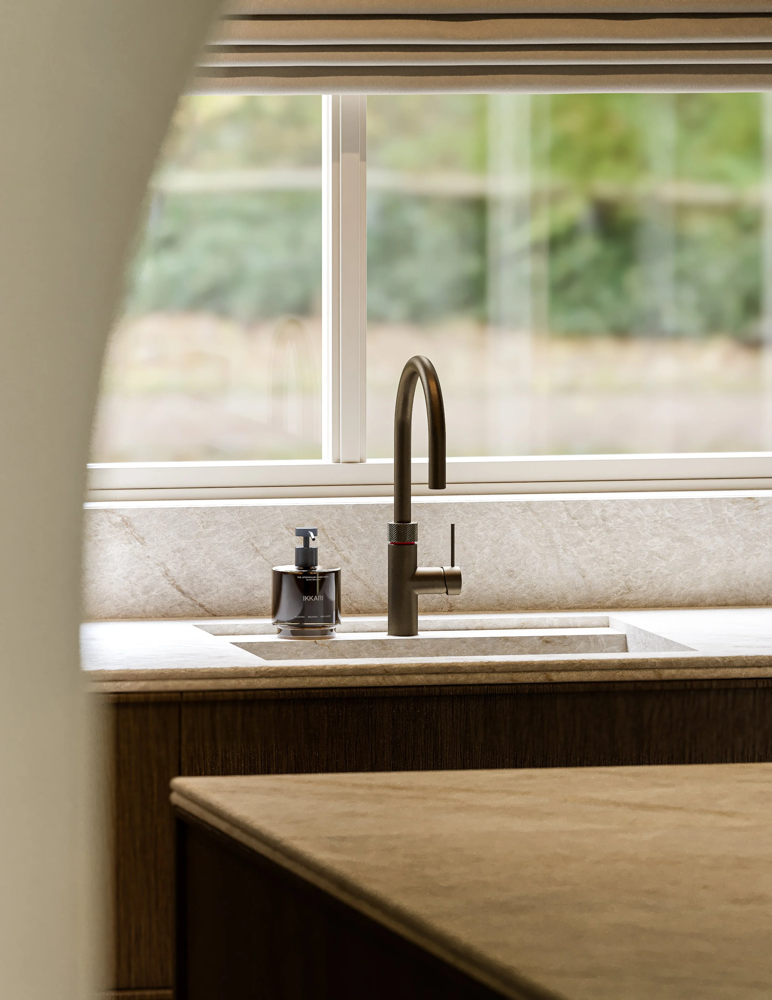Een keuken met een waterkraan, zeeppompje en een raam met uitzicht op groen landschap.