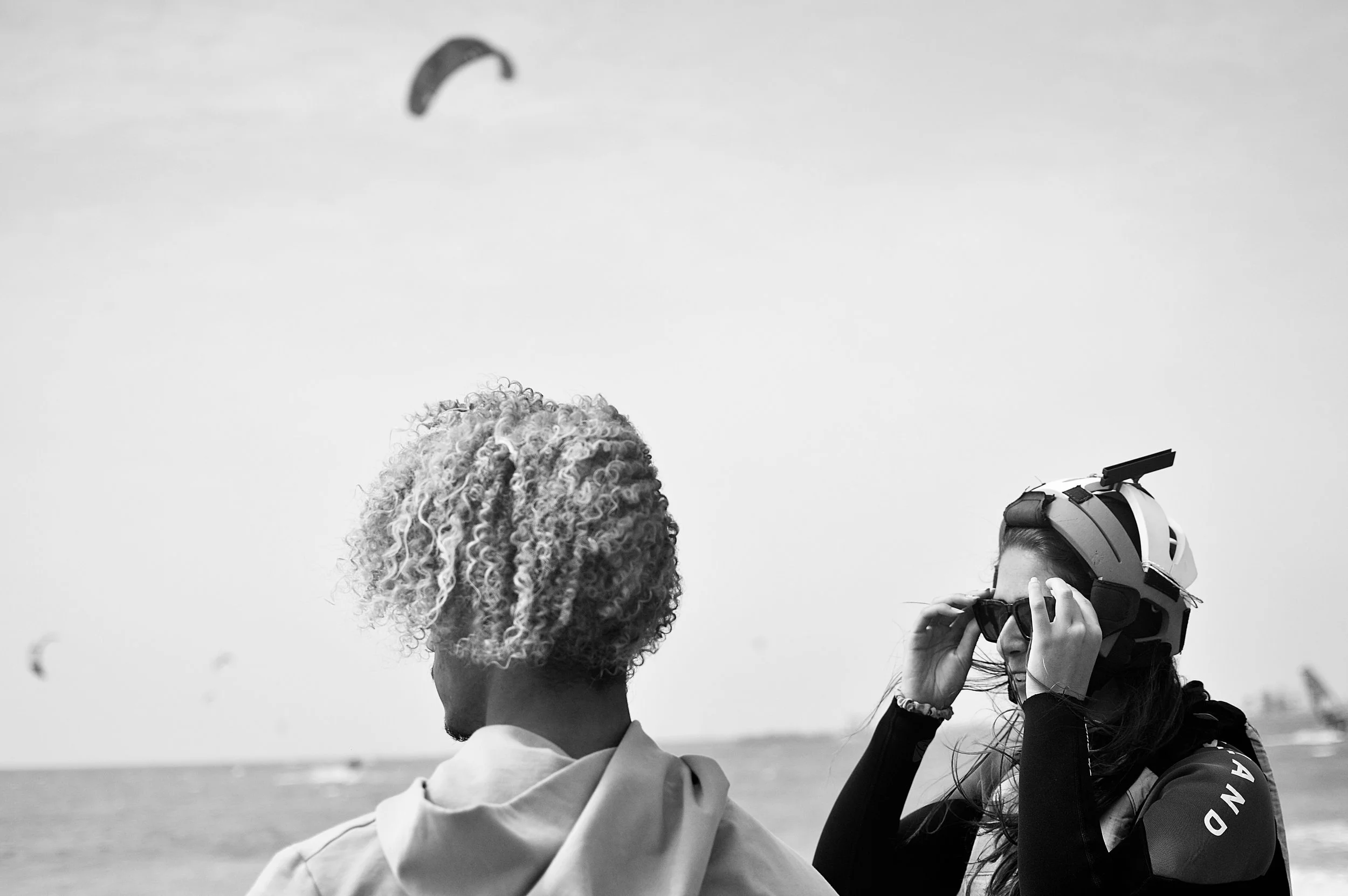 Un profesor de kitesurf y una alumna practicando kitesurf en la playa