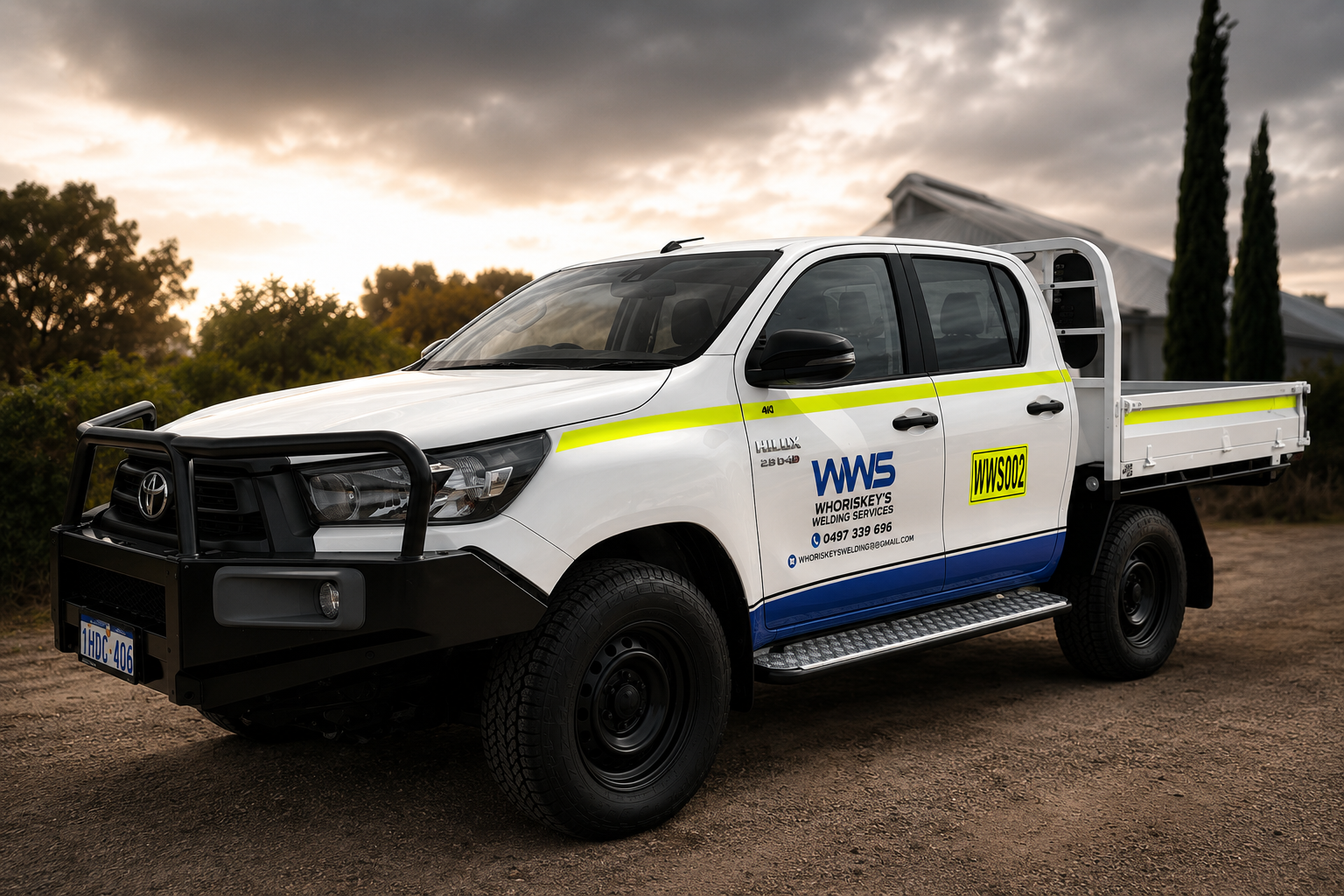White utility pickup truck with company logo and contact information, parked outdoors during sunset