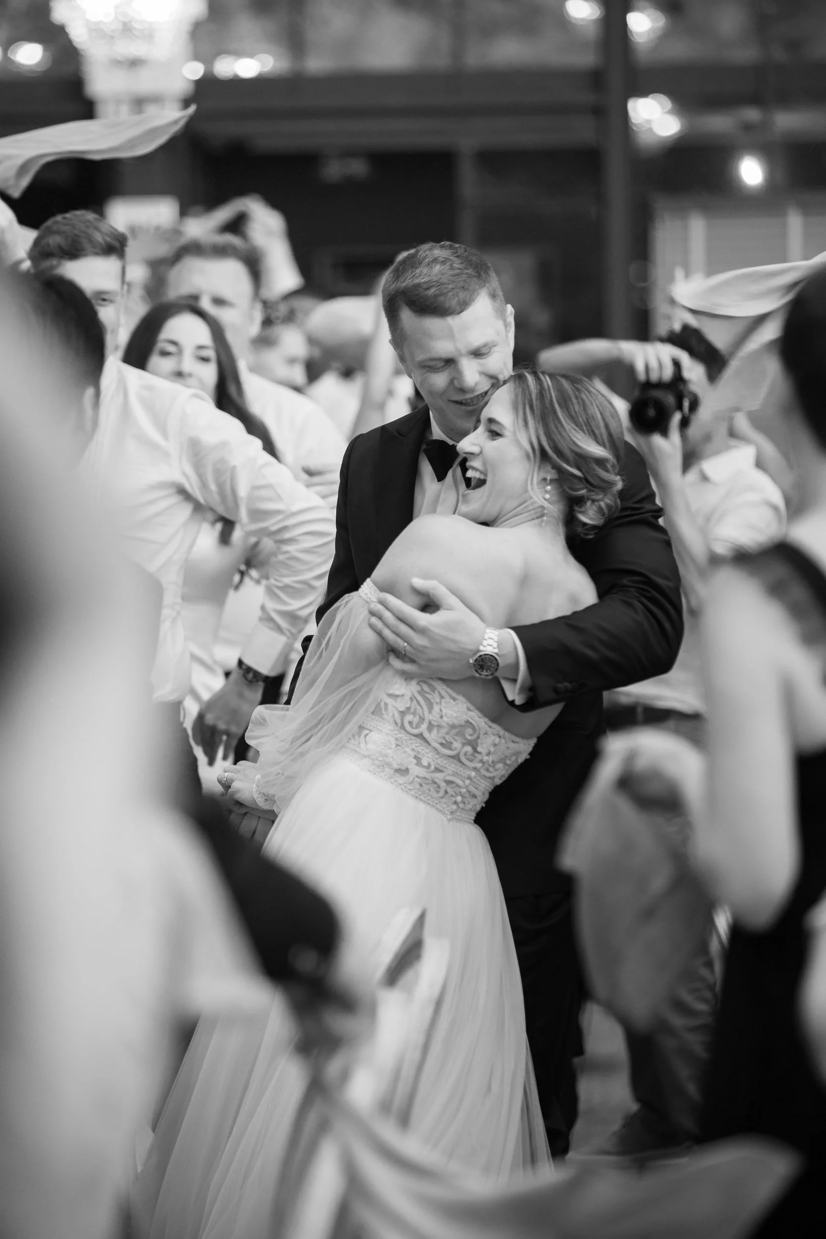 Bride and groom embracing on the dance floor during a joyful wedding celebration