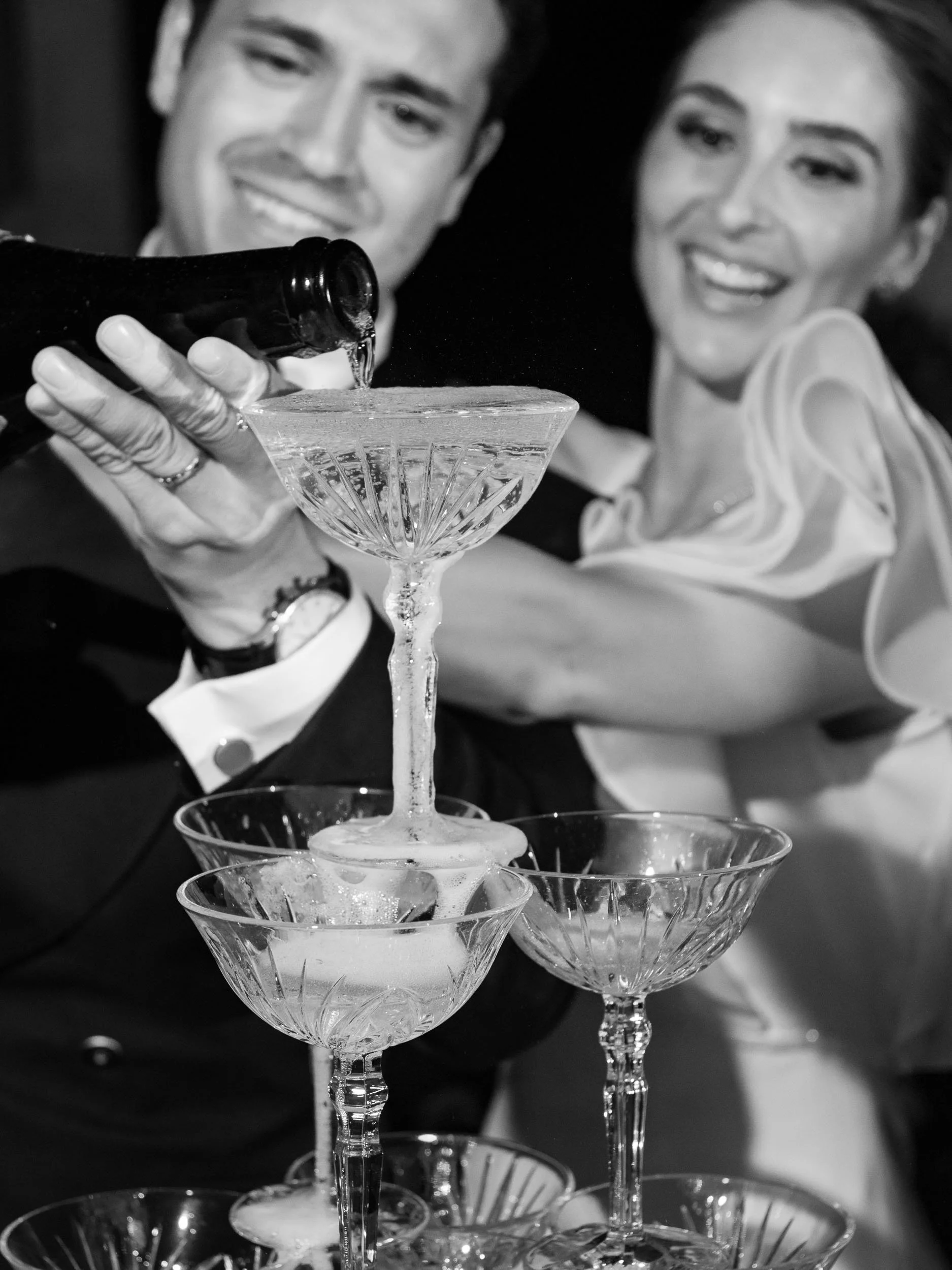 Bride and groom pouring champagne into a champagne tower during a wedding at Vidago Palace Hotel in Portugal