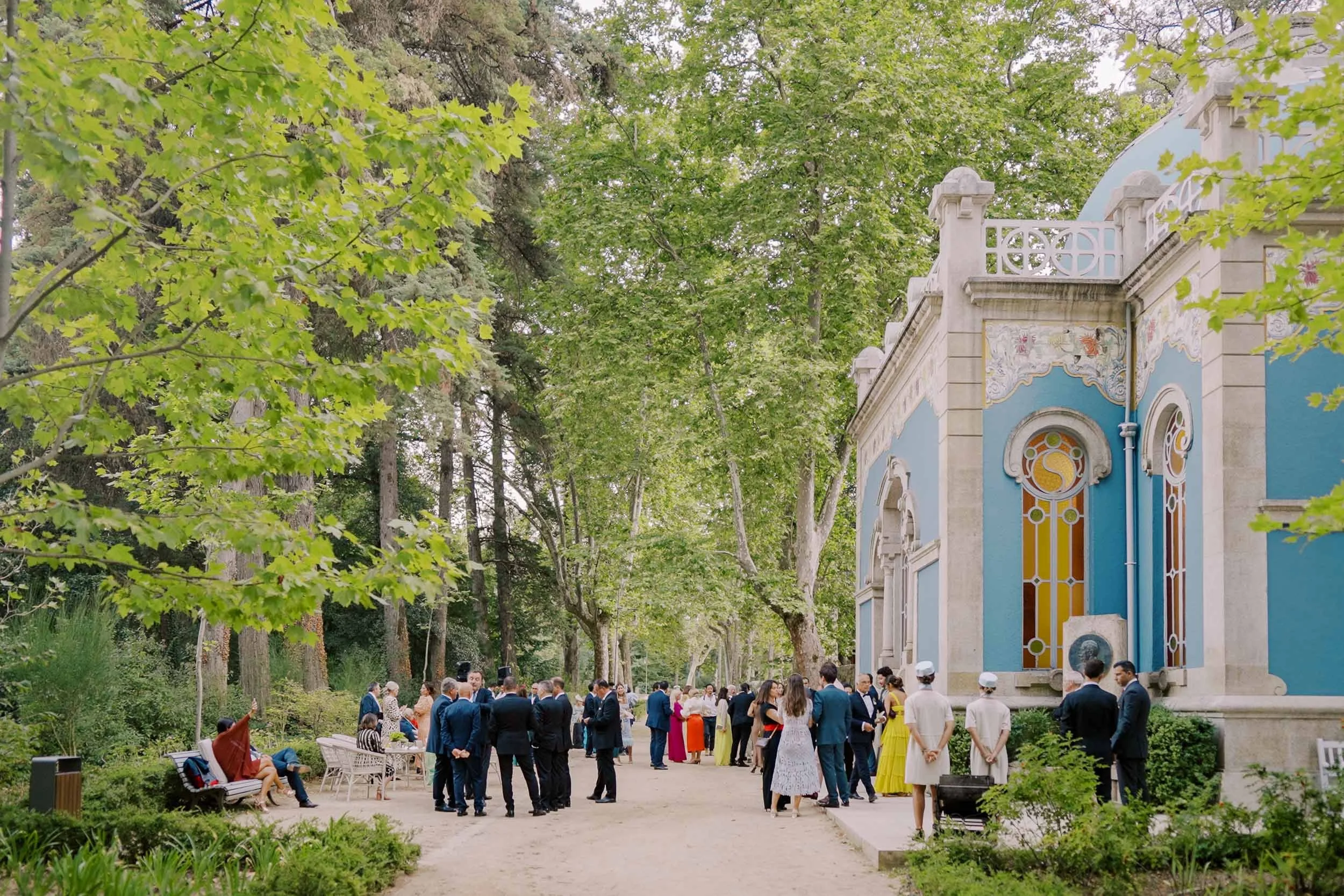 Wedding guests gathering by the Art Nouveau pavilion during a wedding at Vidago Palace Hotel in Portugal