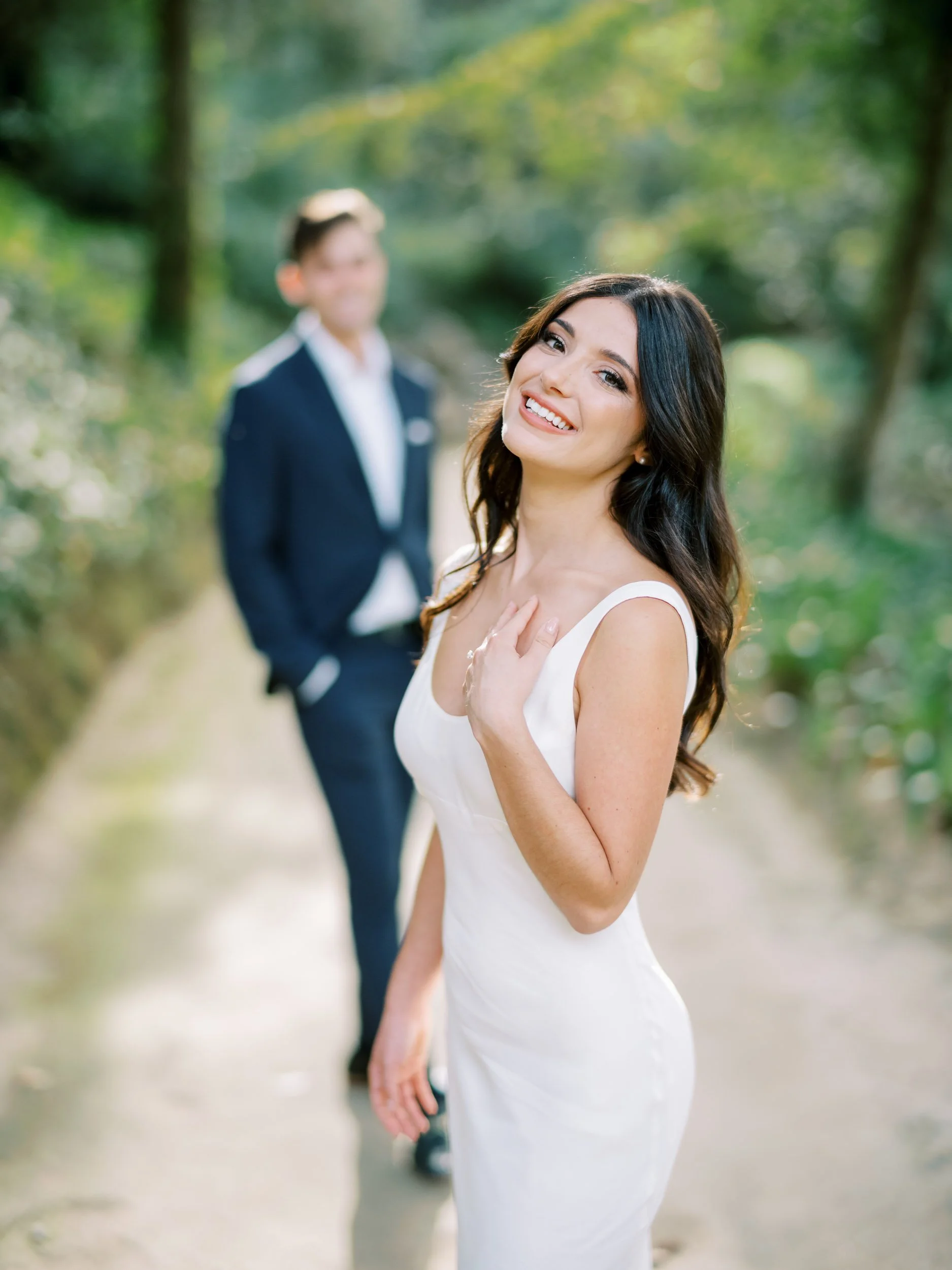 Bride smiling with groom in the background at the gardens of Palácio de Monserrate