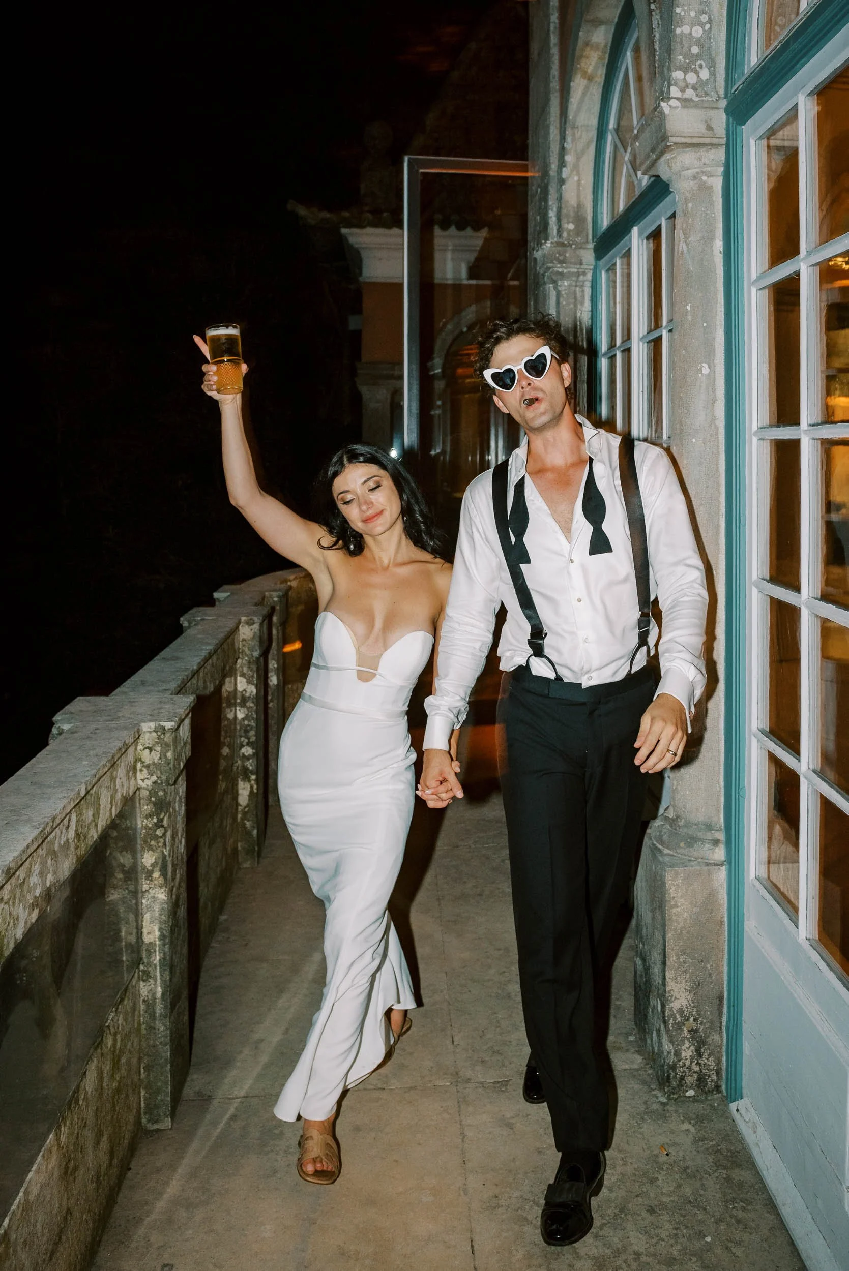 Bride and groom walking on the terrace at night at Casa dos Penedos in Sintra