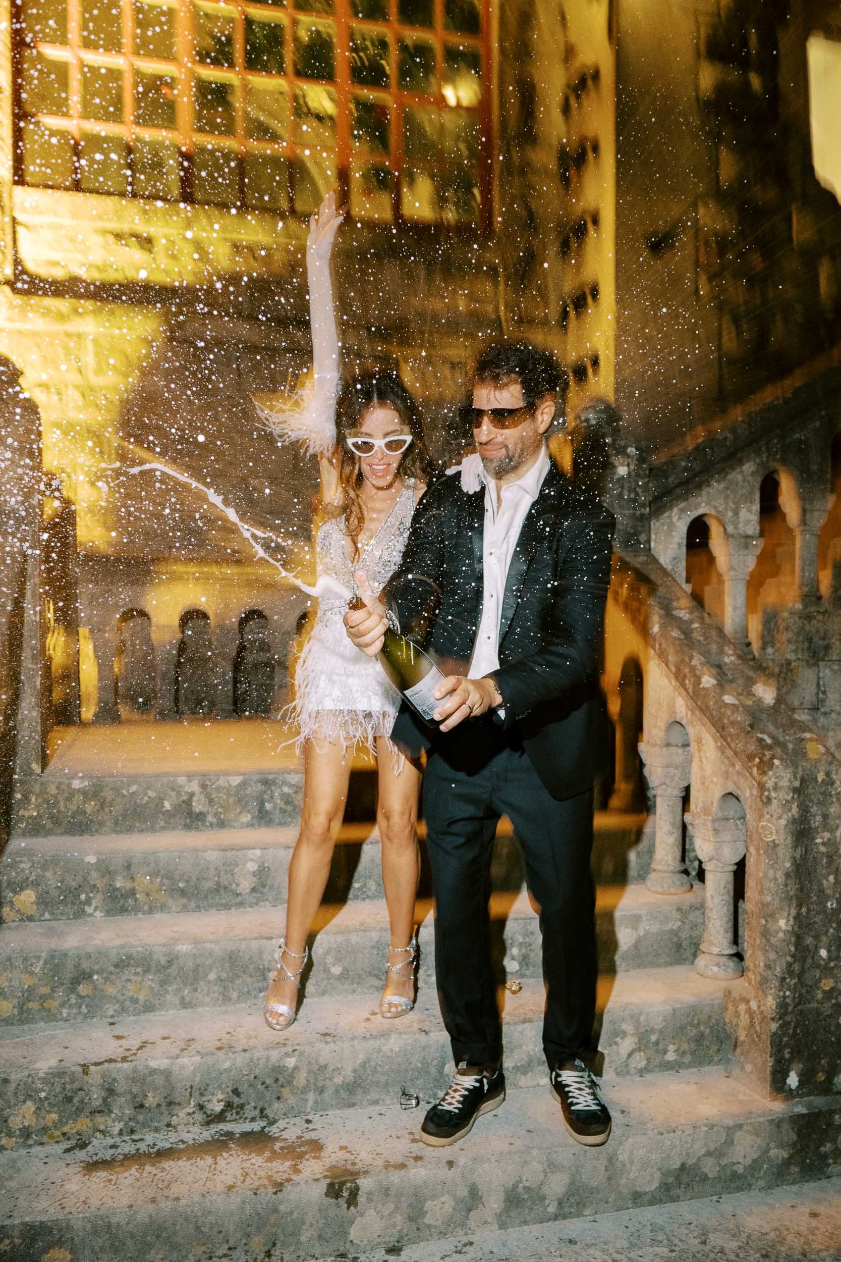 Couple opening a champagne bottle at Forte da Cruz in Estoril, Portugal