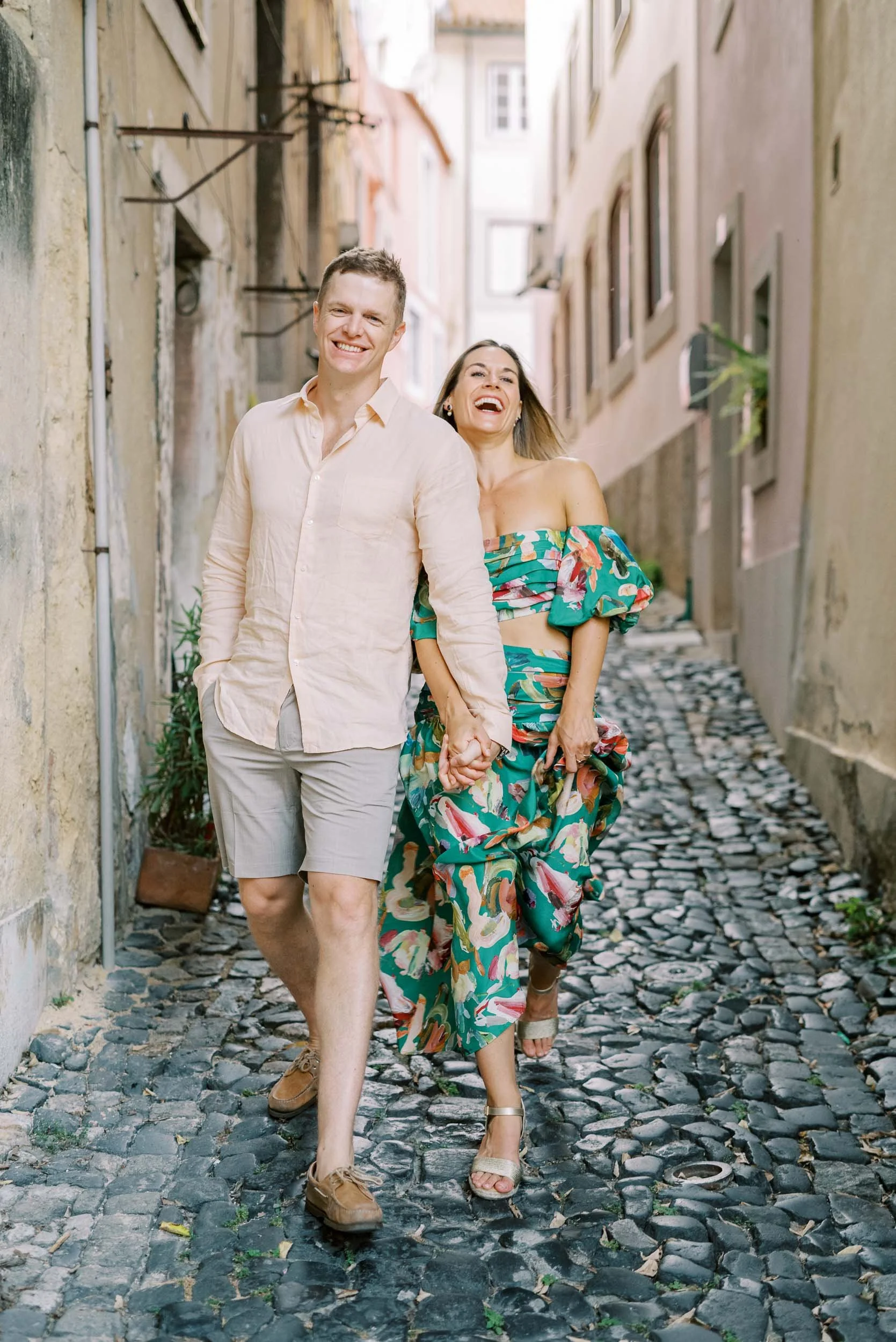 Couple laughing together in a narrow street in old Lisbon before a wedding at Quinta da Bella Vista in Sintra, Portugal